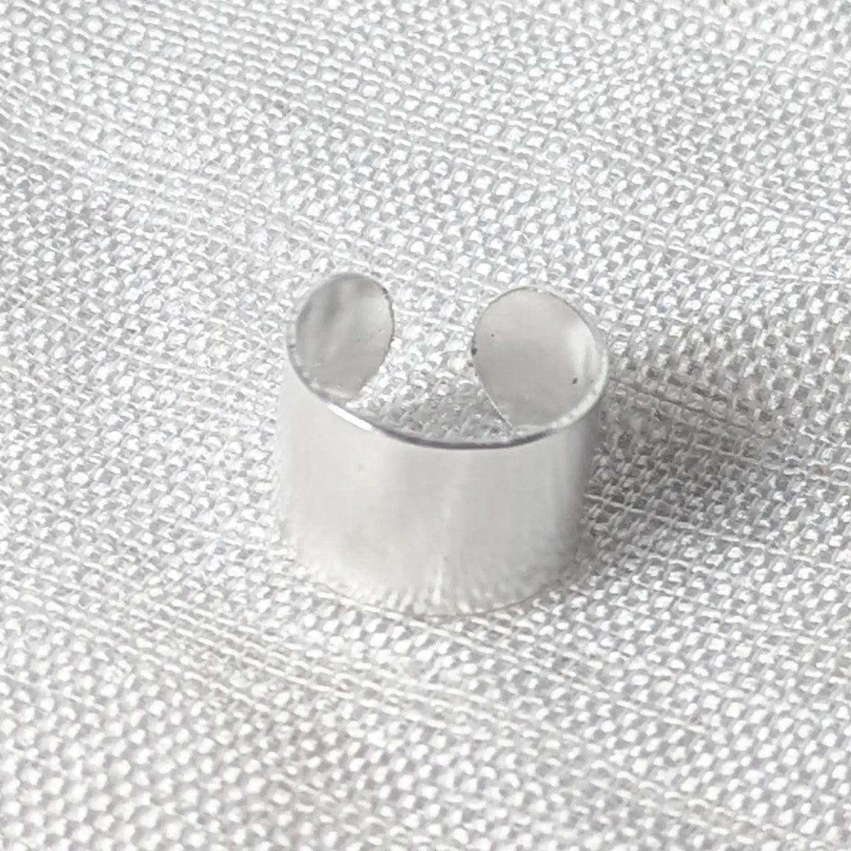 Nahaufnahme einer breiten, glänzenden Ohrklemme aus 925 Silber mit offener, anpassbarer Form