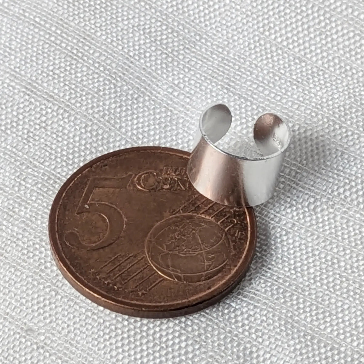 Breite Silber-Ohrklemme flach liegend auf einer 5-Cent-Münze für einen realistischen Größenvergleich.