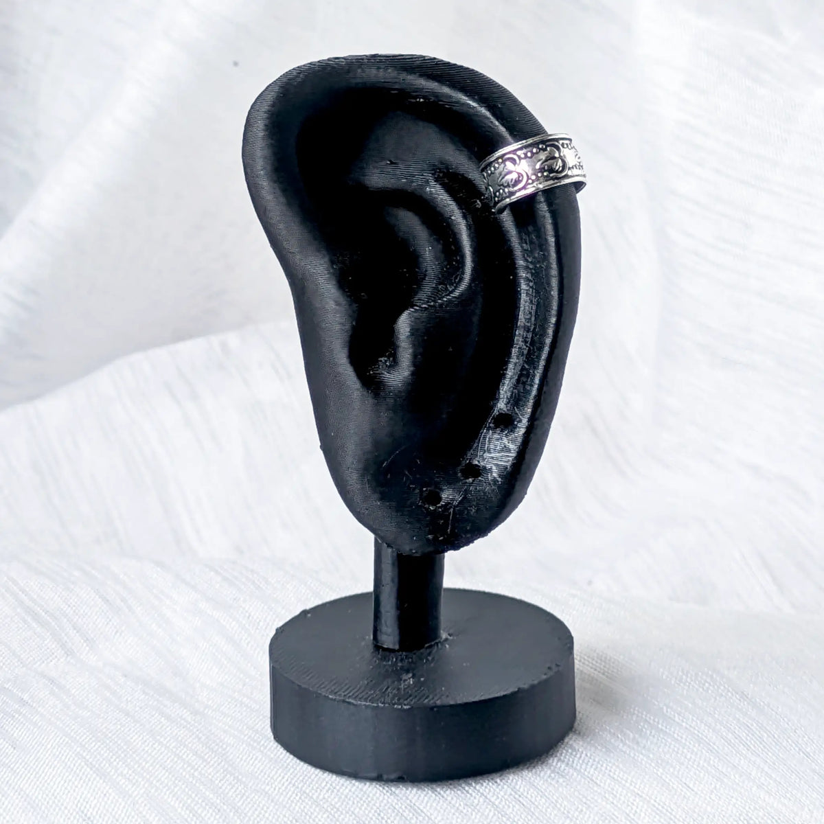 Silberne Vintage Ohrklemme mit Blättermuster, stilvoll getragen am oberen Knorpel eines schwarzen 3D-Ohr-Displays.
