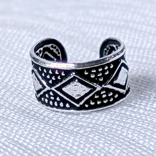 Nahaufnahme eines silbernen Ear Cuffs aus 925 Silber mit geschwärztem Ethno-Rautenmuster.
