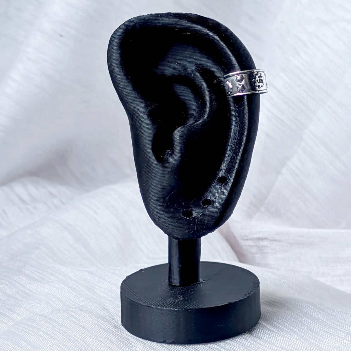 Celestial Ear Cuff aus 925 Silber mit Sonnen-Motiv, stilecht getragen am Knorpel eines schwarzen 3D-Ohr-Modells.