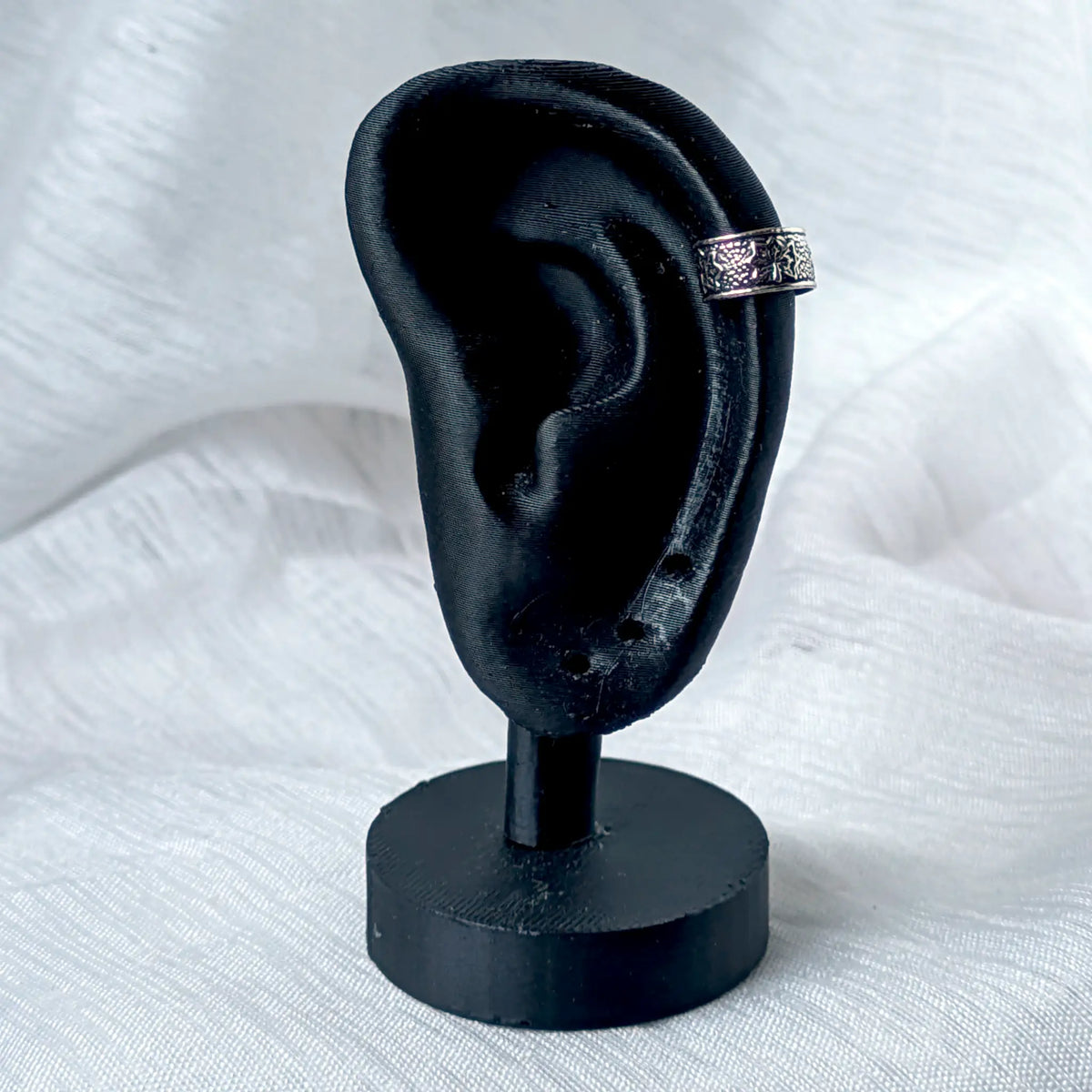 Vintage Ear Cuff aus 925 Silber mit Stern-Muster, stilecht getragen am äußeren Knorpel eines schwarzen 3D-Ohr-Modells.