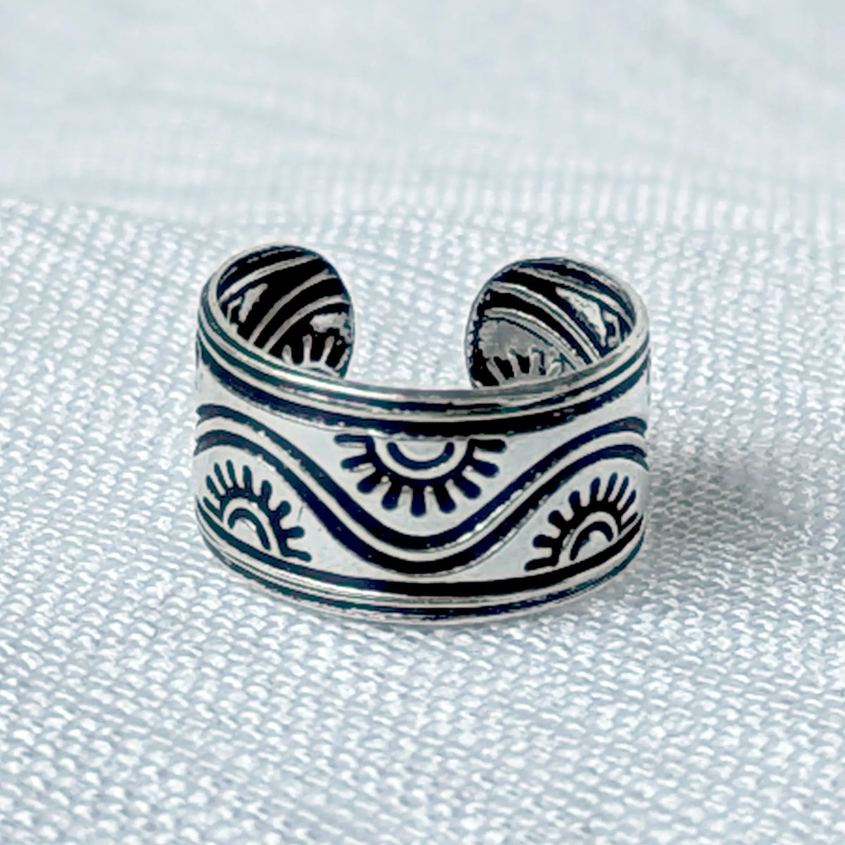 Nahaufnahme eines breiten Ear Cuffs aus 925 Silber mit geschwärztem Wellen- und Sonnen-Muster im Ethno-Stil.