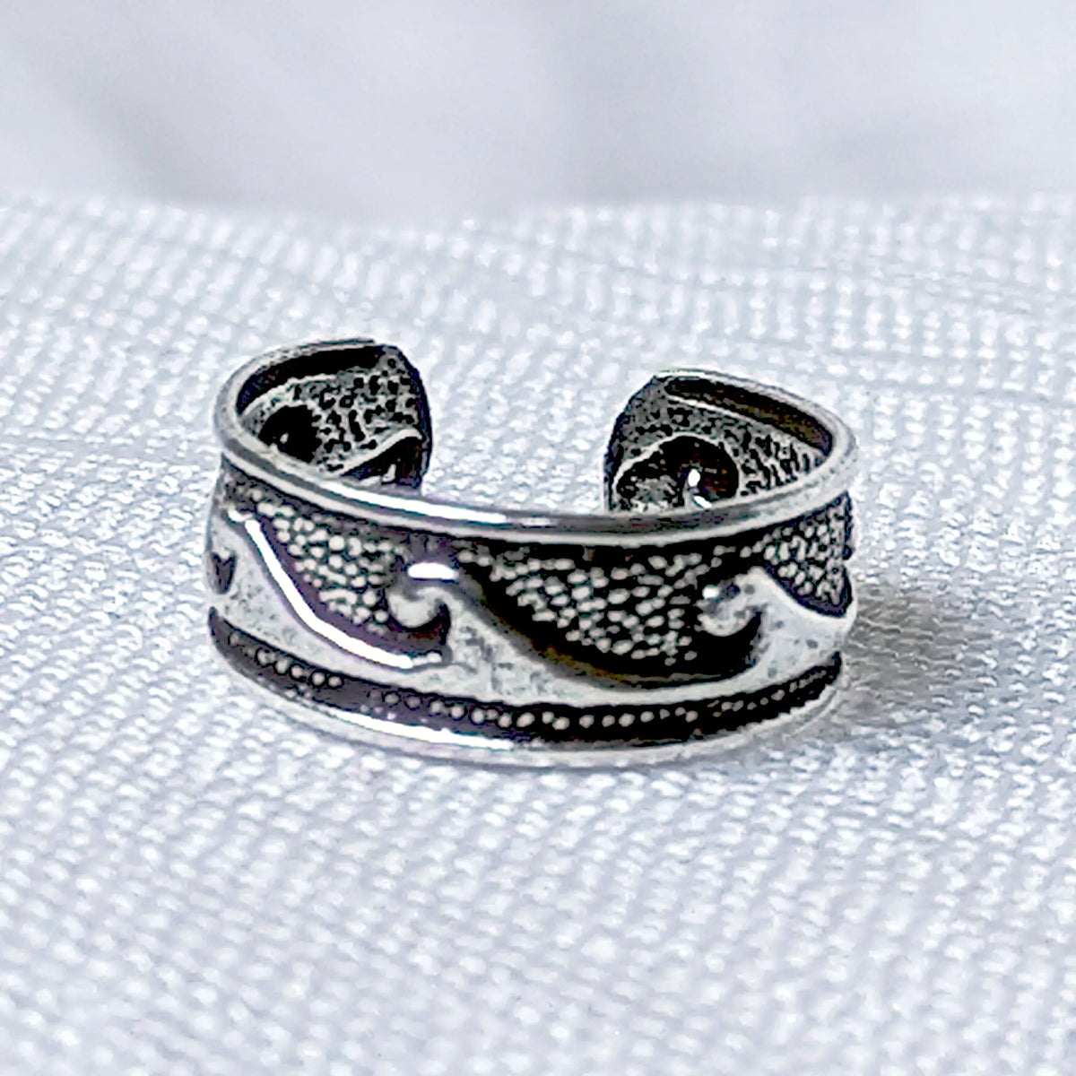 Nahaufnahme eines Ear Cuffs aus 925 Silber mit oxidiertem Vintage Wellen-Muster.