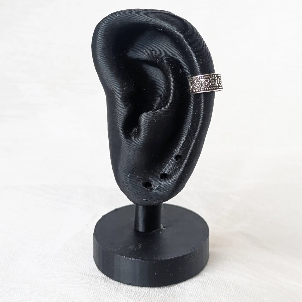 Earcuff Silber 925 am schwarzen Ohr mit filigranen Ornamenten Display Präsentation