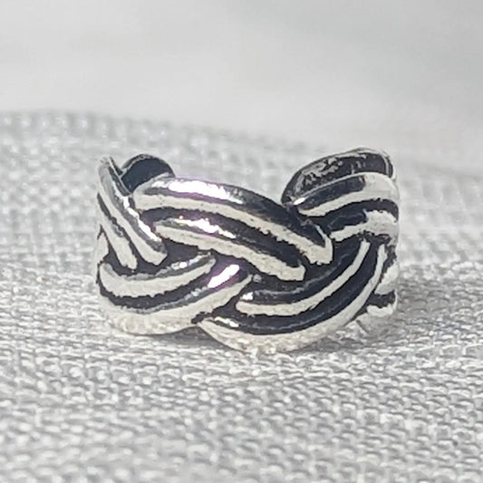 Nahaufnahme einer 925 Silber Ohrklemme mit detailliertem, oxidiertem Flechtmuster.