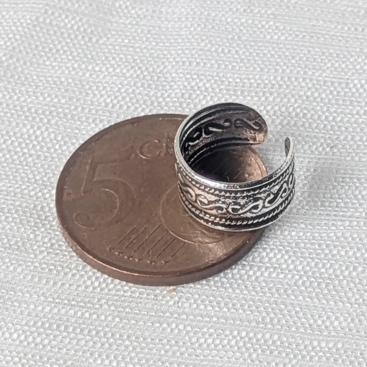 Größenvergleich der breiten 925 Silber Ohrklemme mit Kordelrand, zur exakten Veranschaulichung platziert auf einer 5-Cent-Münze.