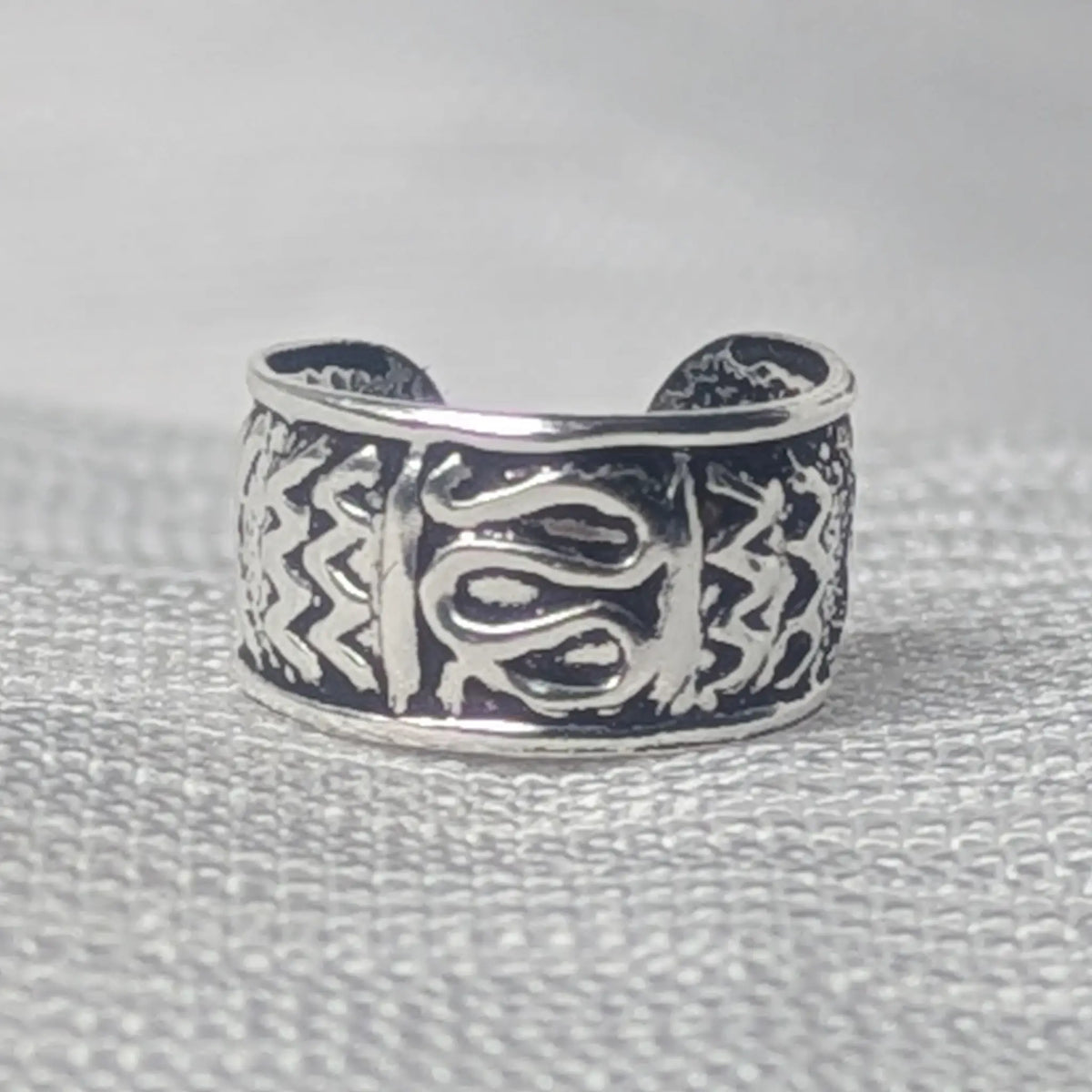 Nahaufnahme einer 925 Silber Ohrklemme mit geschwärztem Tribal- und Zickzack-Muster.