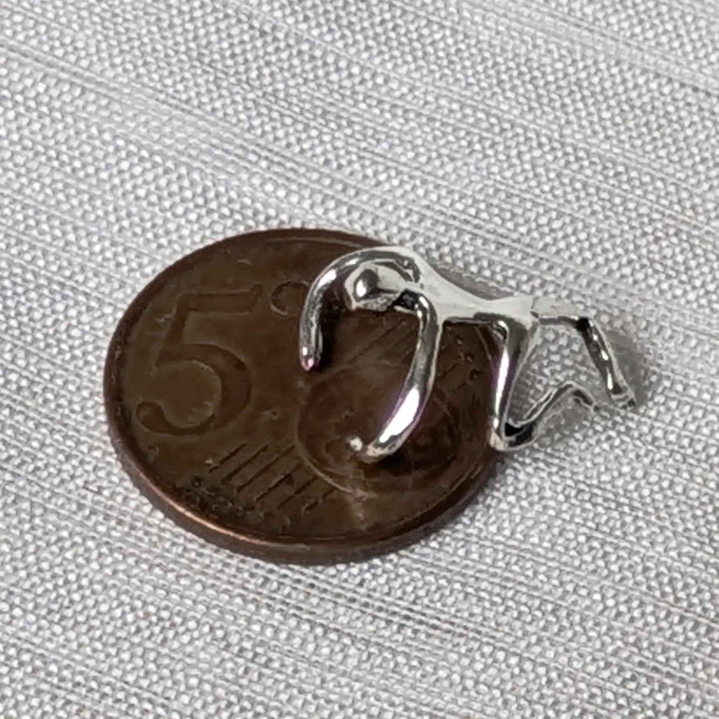Größenvergleich des Kletterer-Earcuffs aus Silber neben einer deutschen 5-Cent-Münze.