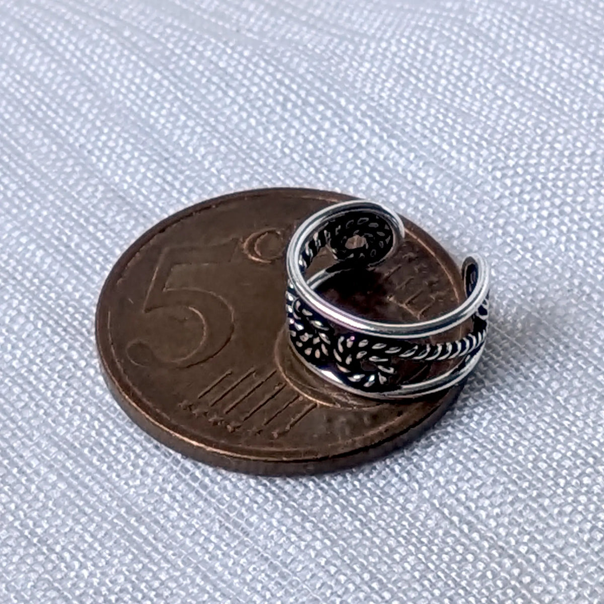 Größenvergleich der durchbrochenen 925 Silber Ohrklemme mit Kordel-Knoten, zur exakten Veranschaulichung platziert auf einer 5-Cent-Münze.