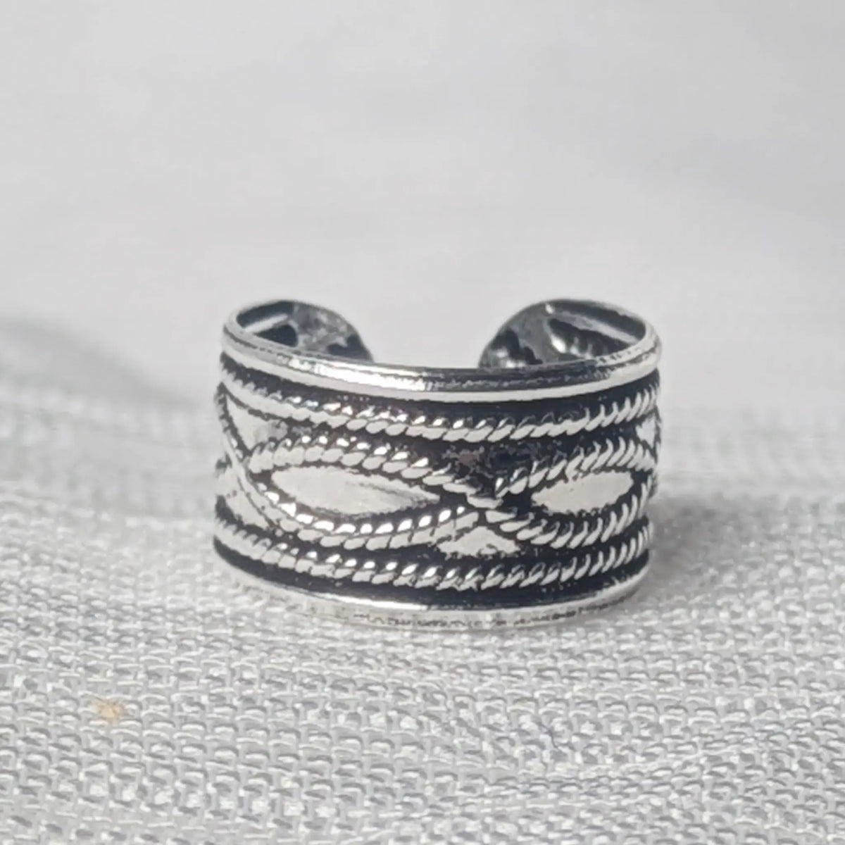 Nahaufnahme einer 925 Silber Ohrklemme mit detailreichem, geschwärztem Kordelmuster.