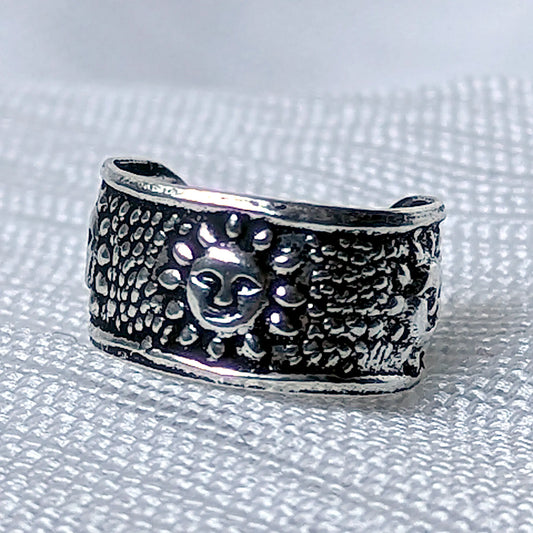 Nahaufnahme einer breiten Ohrklemme aus 925 Silber mit erhabenem Sonnen-Gesicht und strukturierter, geschwärzter Oberfläche.