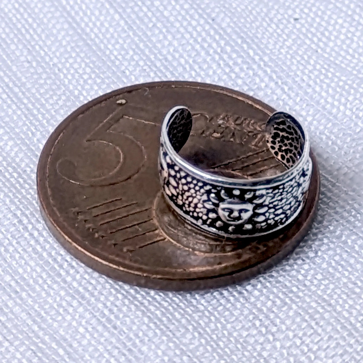 Größenvergleich der breiten, texturierten 925 Silber Ohrklemme mit Sonnen-Motiv, zur exakten Veranschaulichung platziert auf einer 5-Cent-Münze.