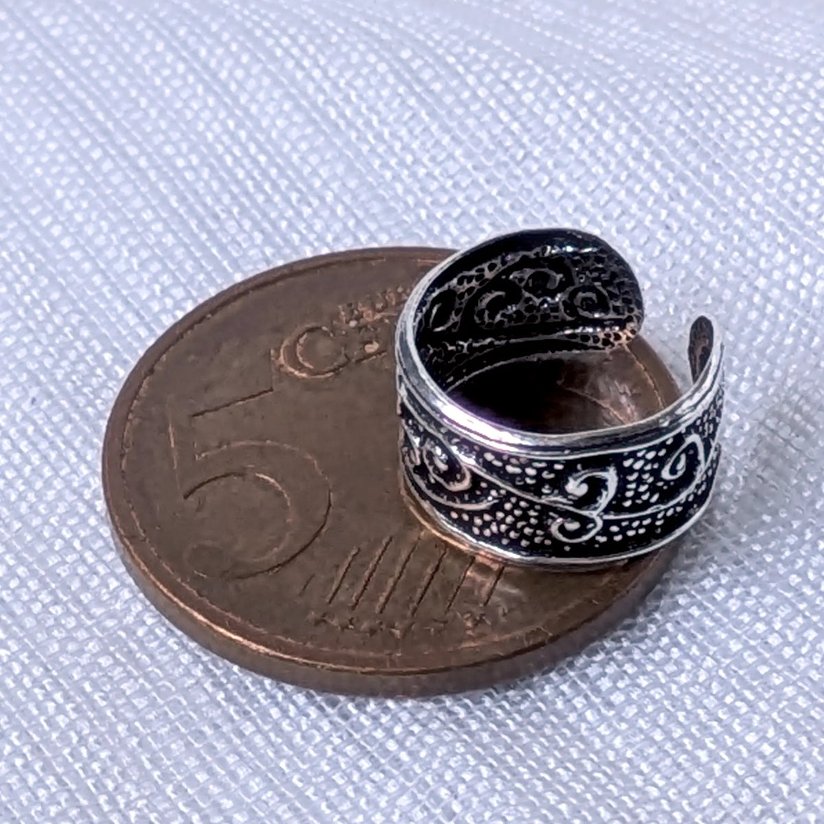 Größenvergleich der breiten, texturierten 925 Silber Ohrklemme mit Wellenmuster, zur exakten Veranschaulichung platziert auf einer 5-Cent-Münze.