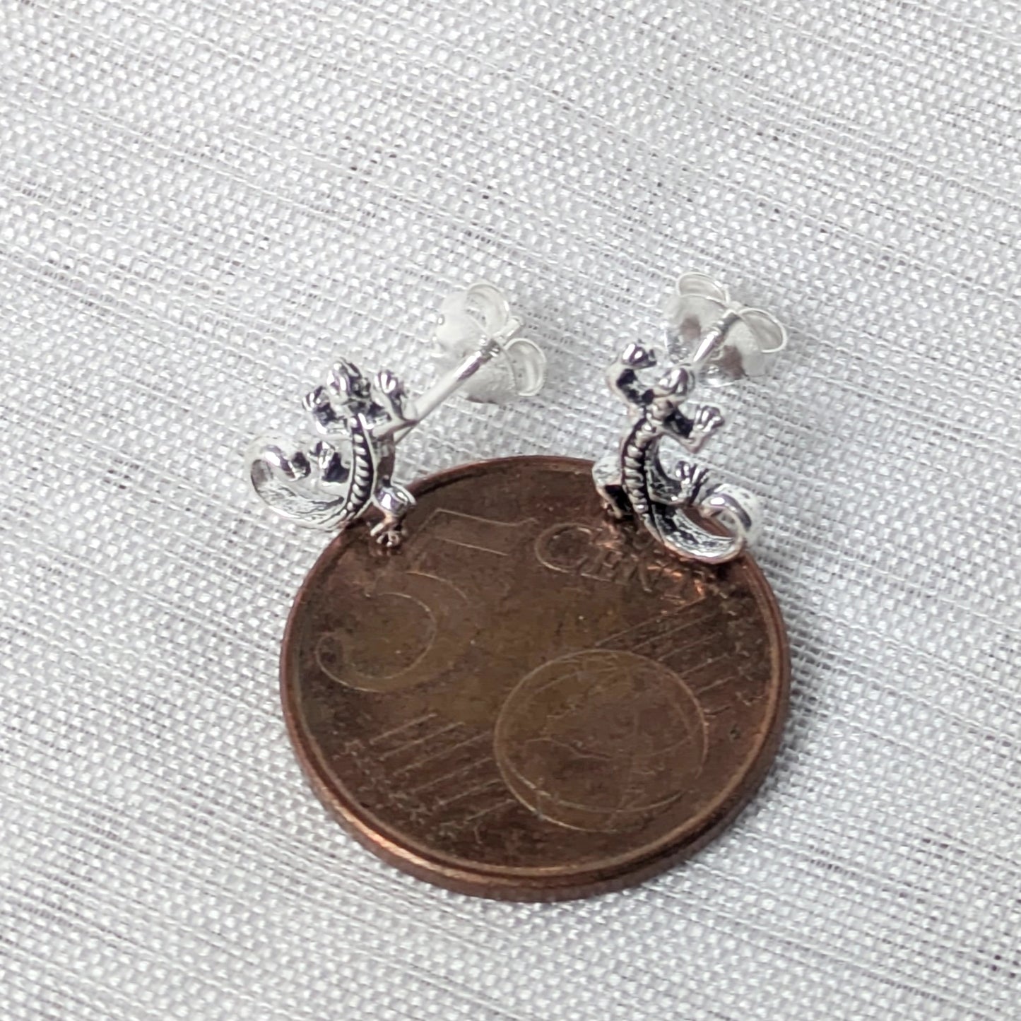 Größenvergleich der kleinen Eidechsen Ohrringe liegend auf einer 5-Cent-Münze.