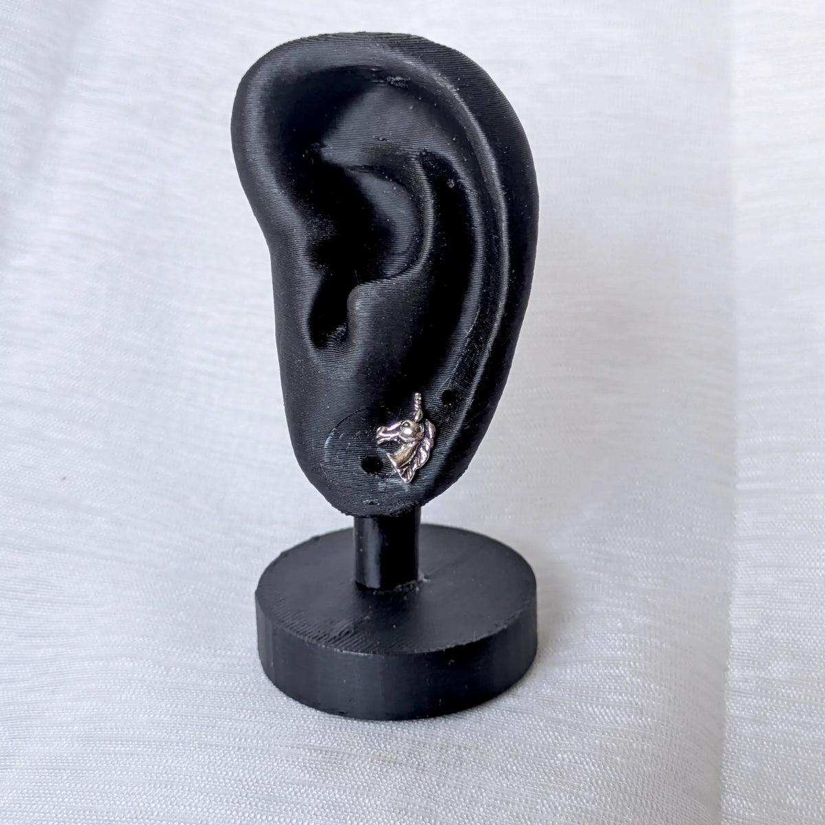 Einhorn Ohrstecker 925 Silber getragen am schwarzen Ohr-Display zur Veranschaulichung der Sitzposition