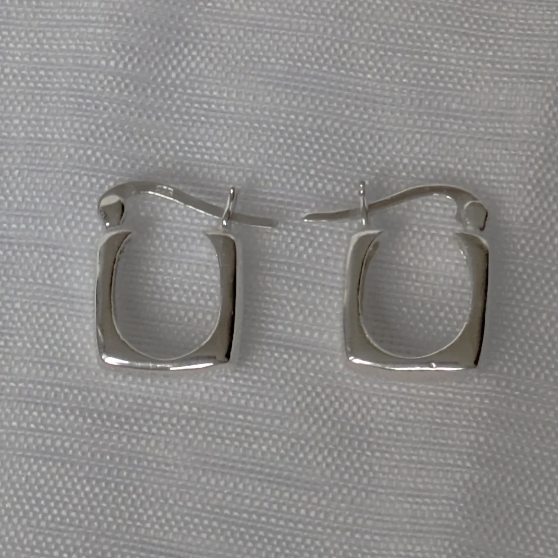 Detailansicht der quadratischen 925 Sterling Silber Creolen glänzend poliert.