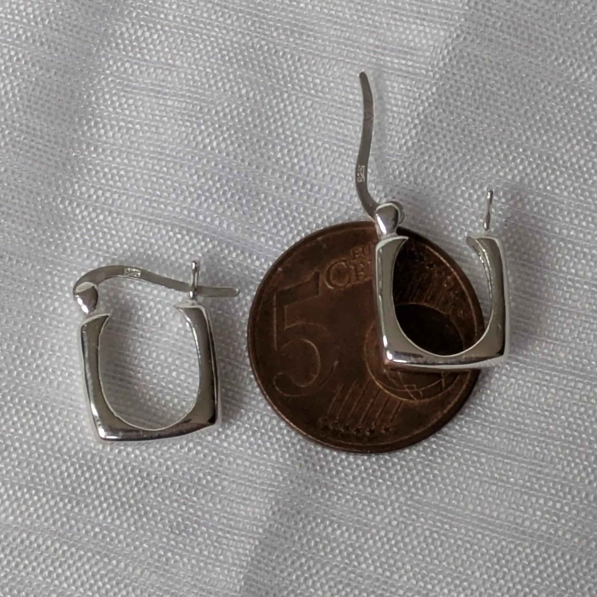 Größenvergleich der kleinen quadratischen Silber-Creolen auf einer 5-Cent-Münze.