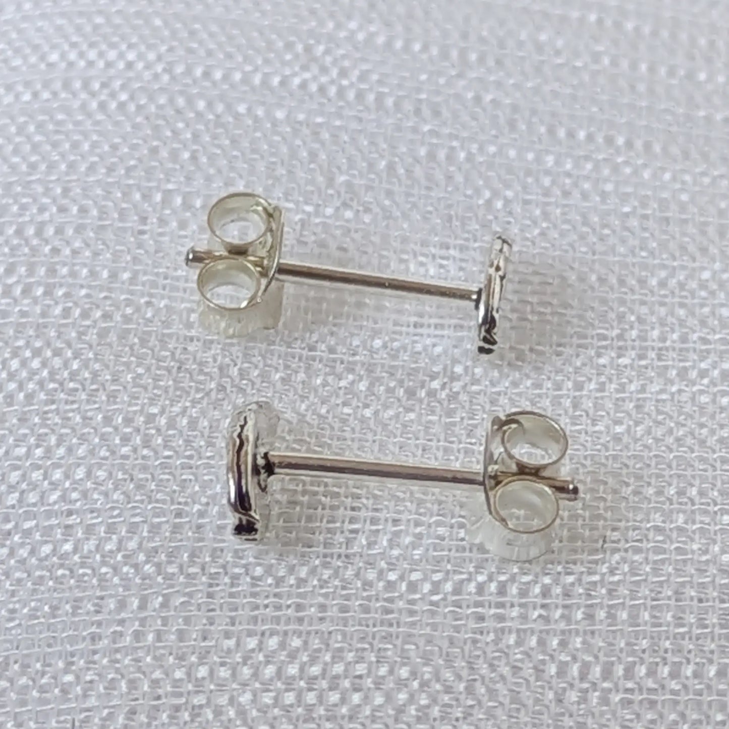 Seitenansicht der silbernen Engelsflügel Ohrstecker mit Steckerstift und geschwungenem Profil.