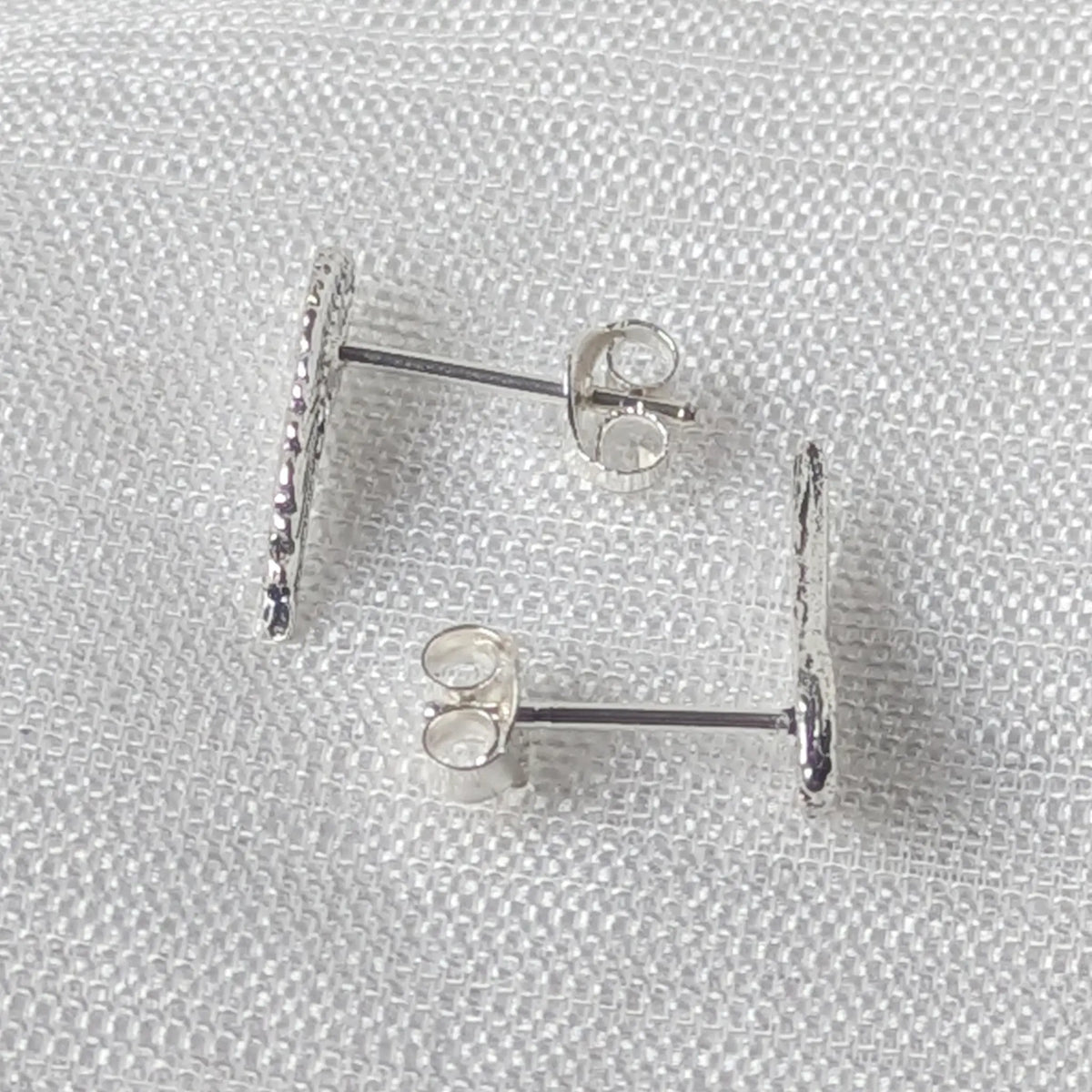 Seitliche Perspektive der leicht geschwungenen Engelsflügel Ohrringe aus echtem Sterling Silber.