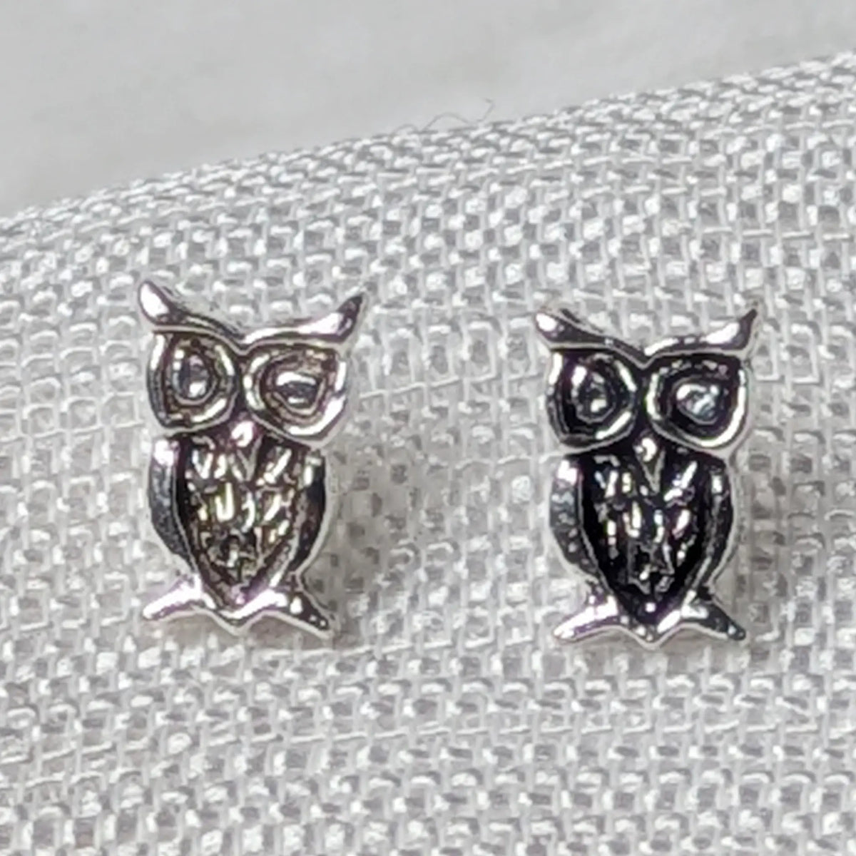 Nahaufnahme von 925 Silber Ohrsteckern in Eulenform mit detailliert ausgearbeitetem Federkleid und großen Augen.