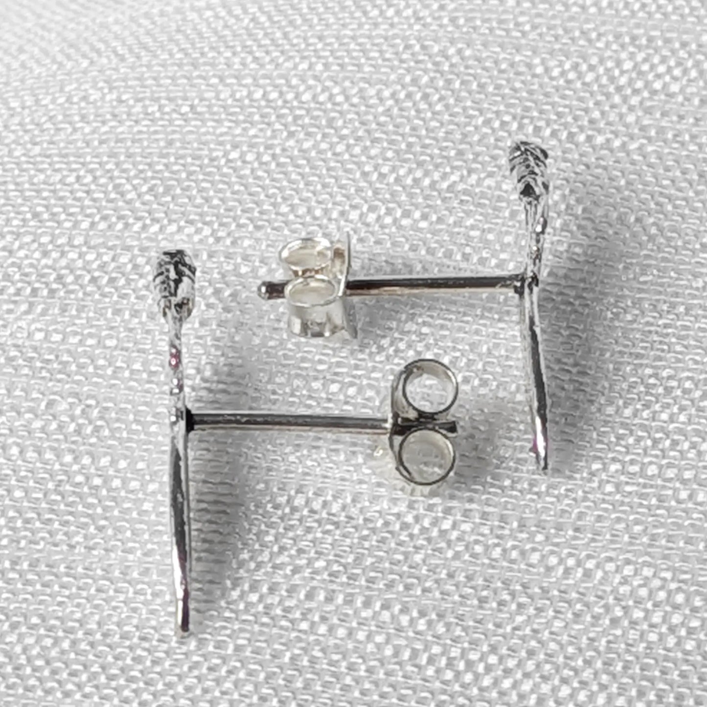 Seitliche Ansicht der Feder-Ohrstecker aus Silber zur Verdeutlichung der flachen, eleganten Form`