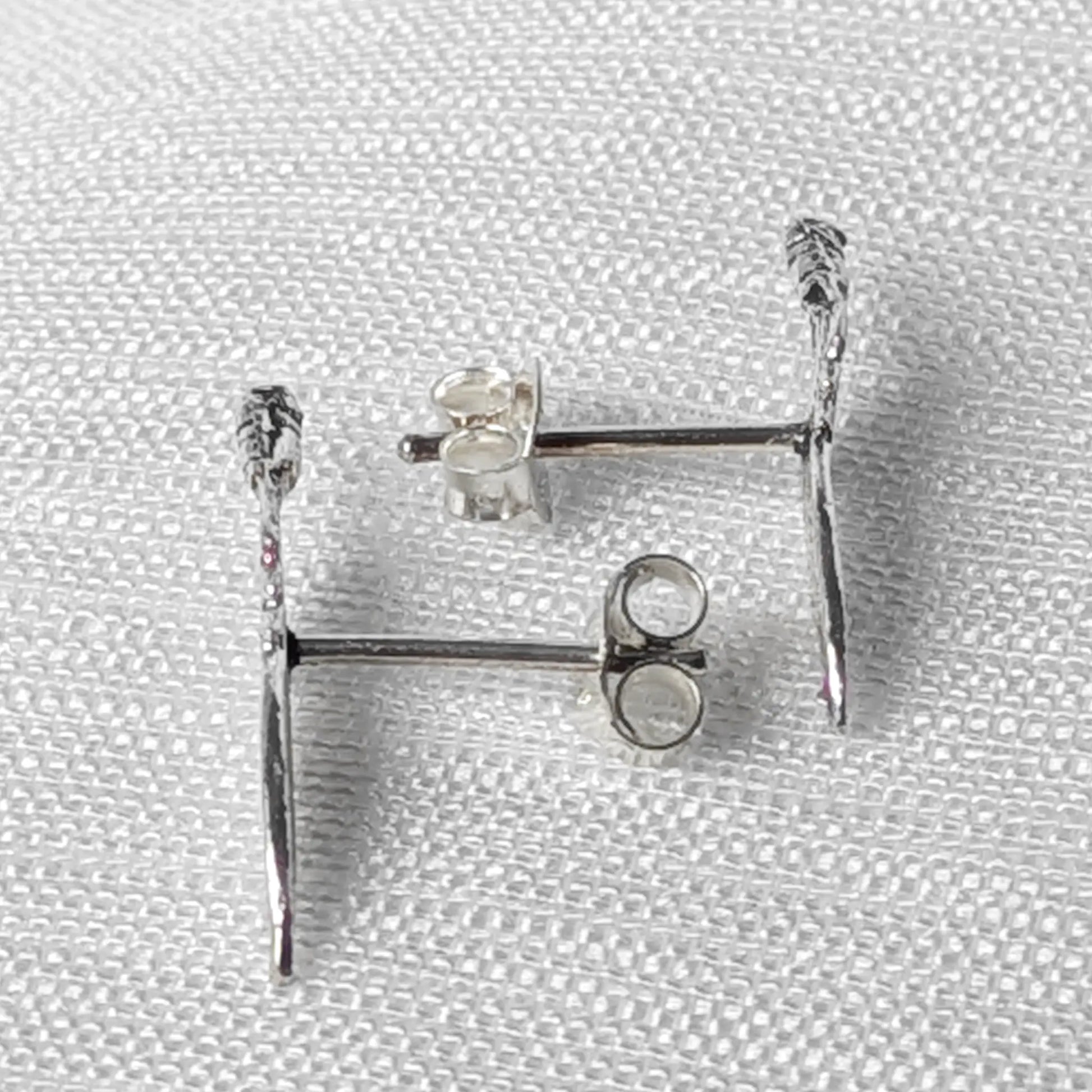 Seitliche Ansicht der Feder-Ohrstecker aus Silber zur Verdeutlichung der flachen, eleganten Form`
