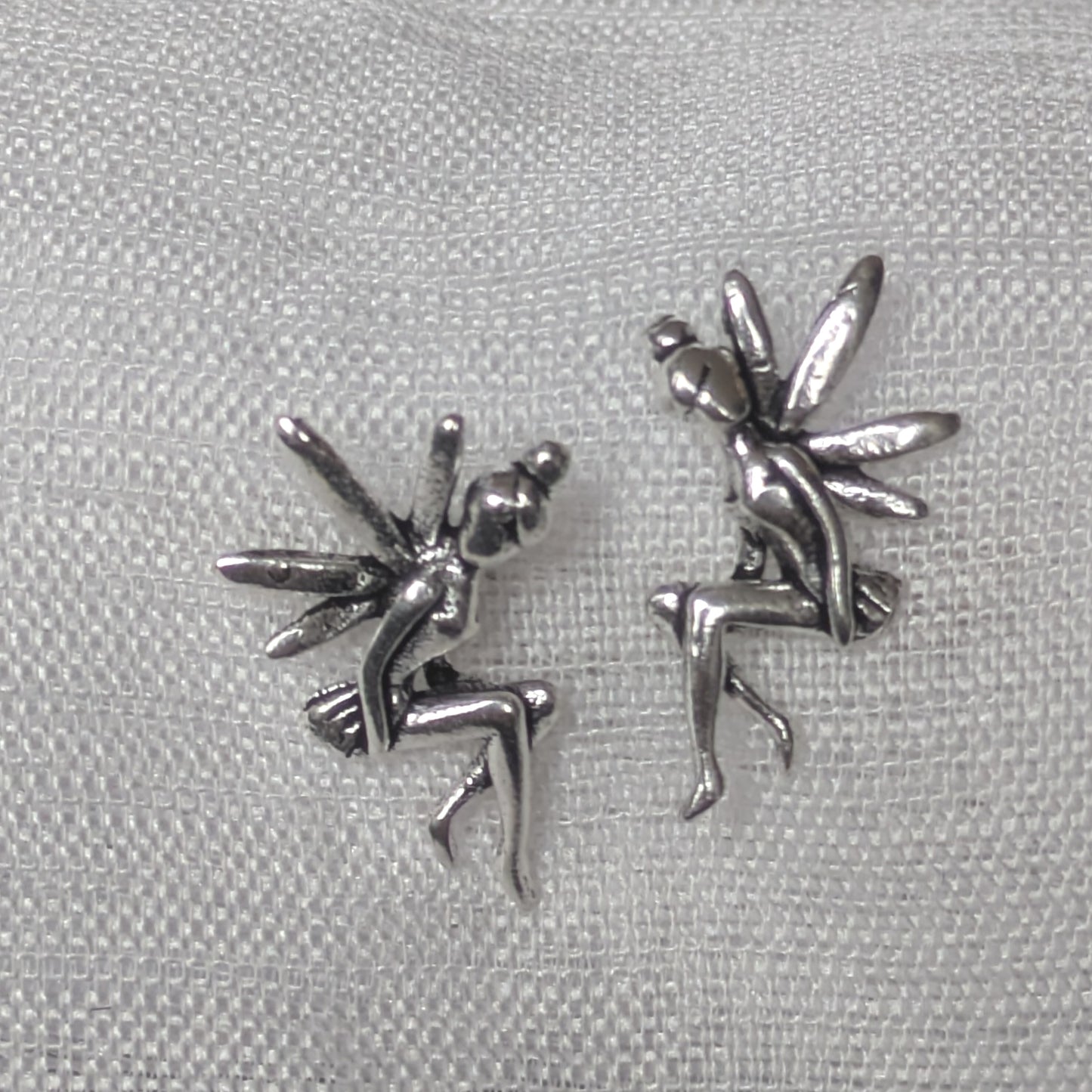 Frontalansicht der Feen-Ohrstecker aus 925 Sterling Silber; die detaillierten Flügel und die sitzende Pose der Elfen sind vor hellem Hintergrund klar erkennbar.