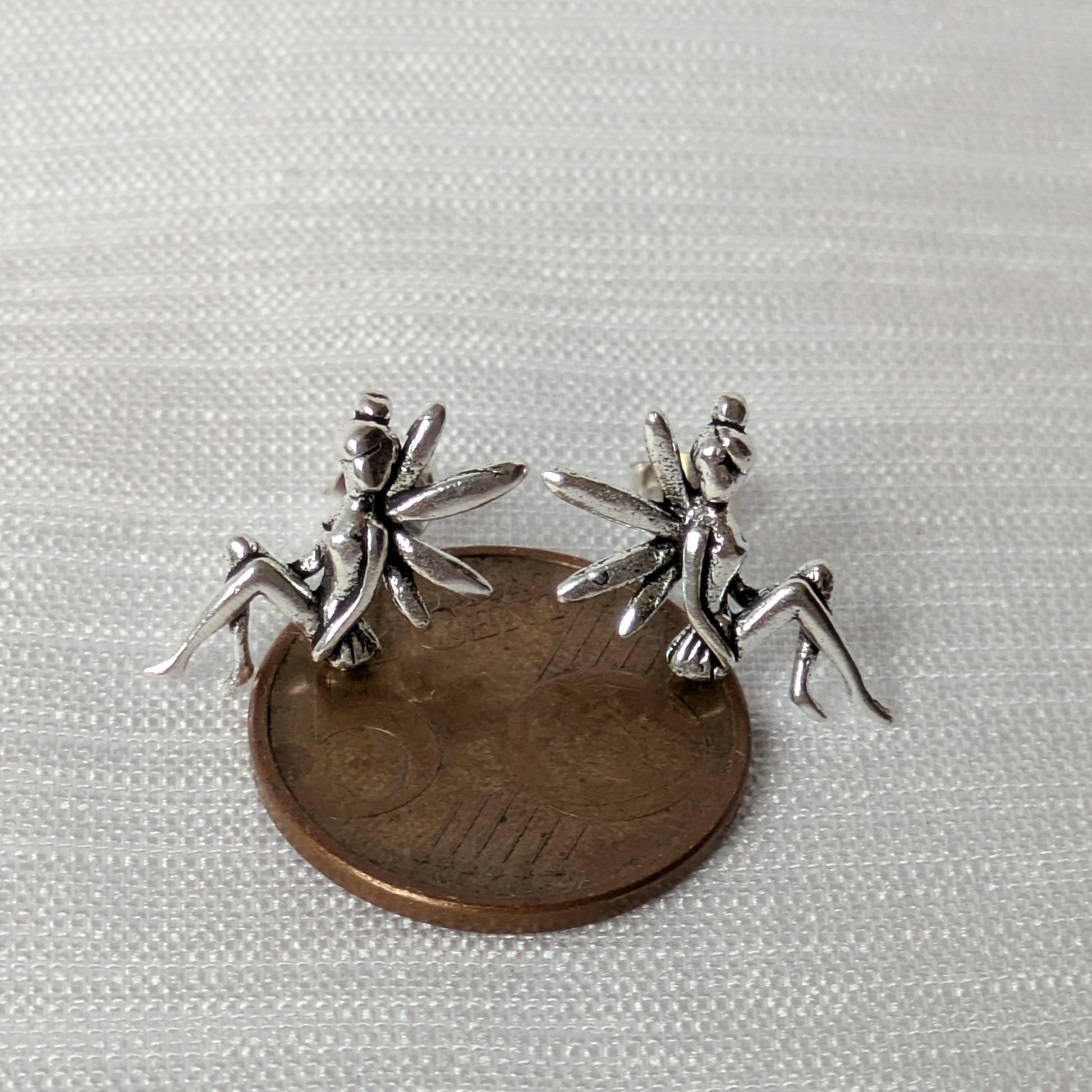 Größenvergleich der silbernen Elfen-Ohrringe auf einer 5-Cent-Münze liegend; verdeutlicht die winzigen, meisterhaften Details des Miniatur-Designs.