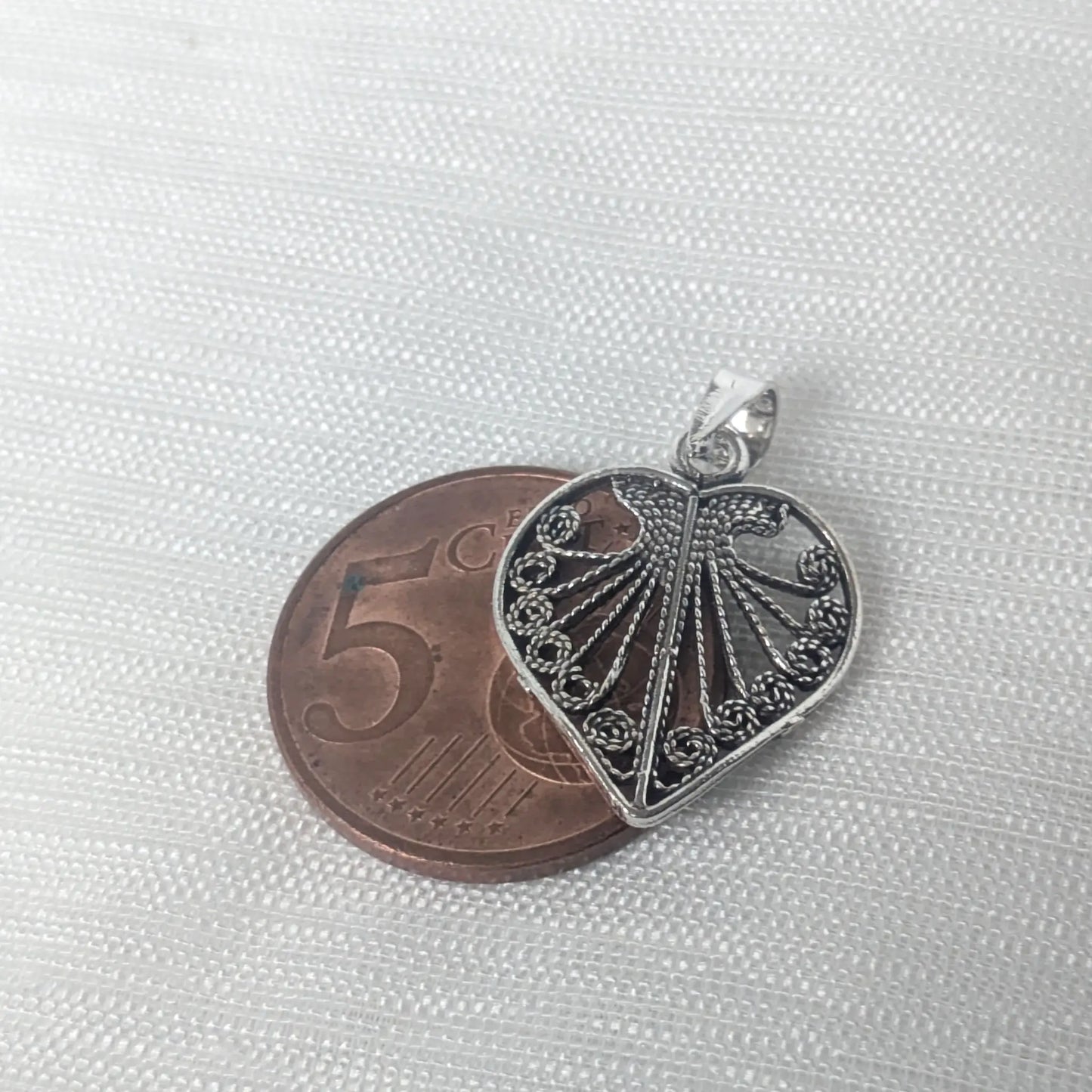 Größenvergleich des detailreichen Vintage Herz-Kettenanhängers auf einer 5-Cent-Münze zur Veranschaulichung der realen Proportionen.