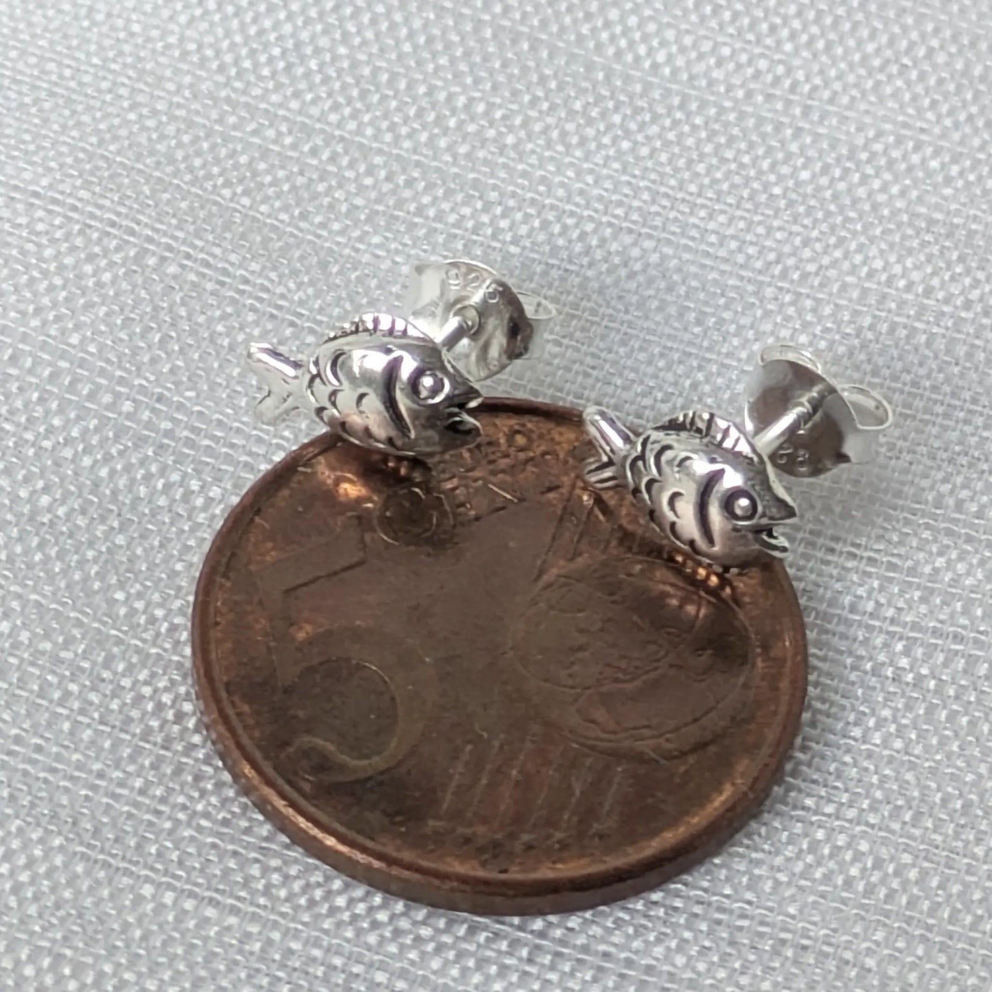 Größenvergleich Fisch Ohrstecker Silber neben 5-Cent-Münze