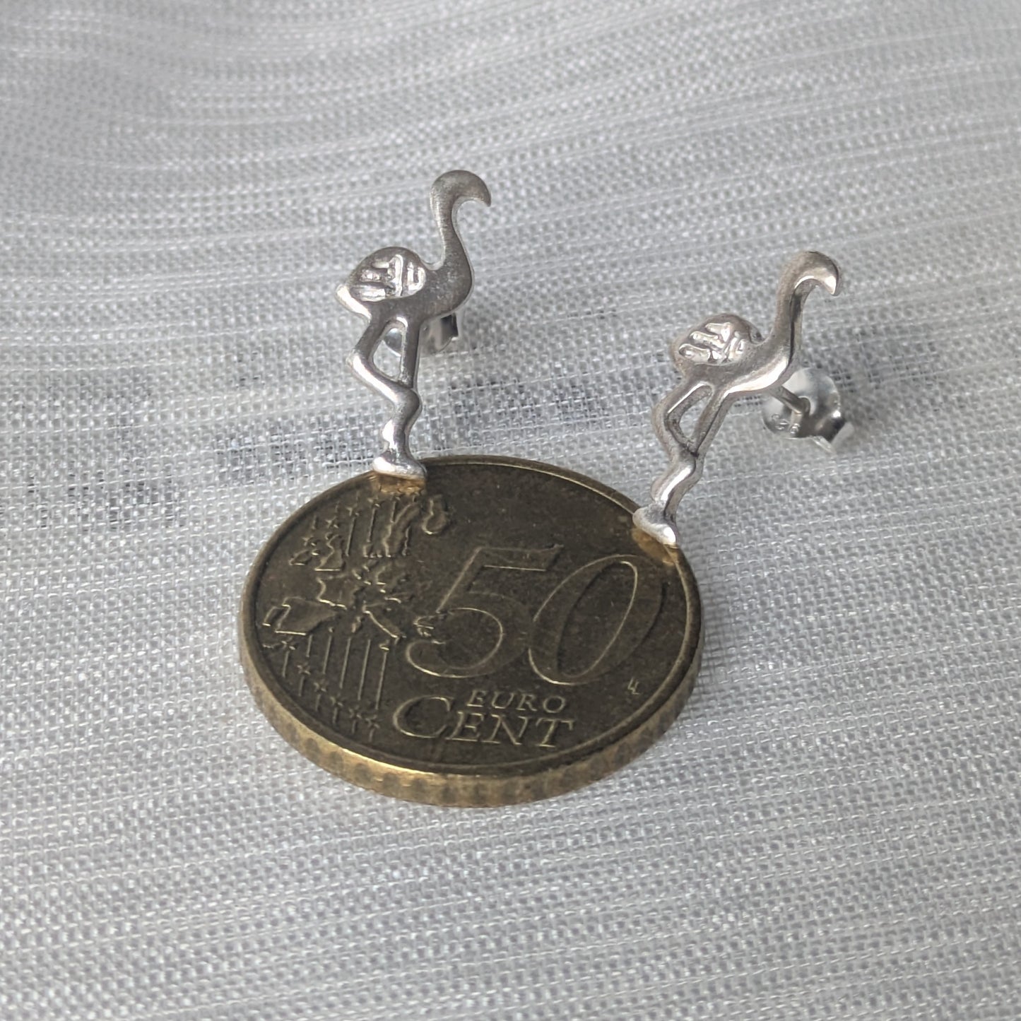 Größenvergleich der minimalistischen Flamingo-Ohrringe aus Silber mit 50-Cent-Münze für eine realistische Einschätzung der Passform