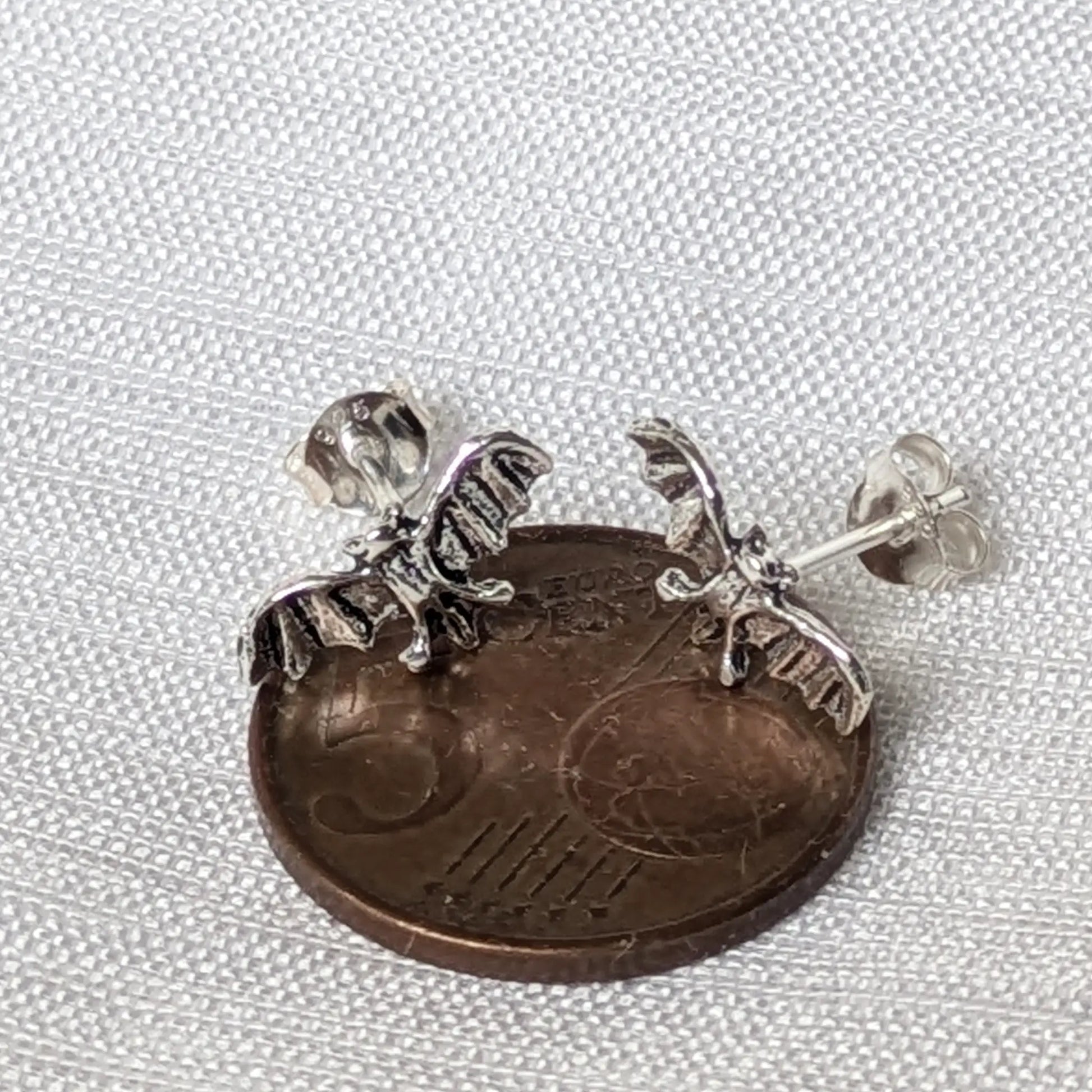 Größenvergleich: Kleine Fledermaus Ohrringe Silber auf einer 5-Cent-Münze.