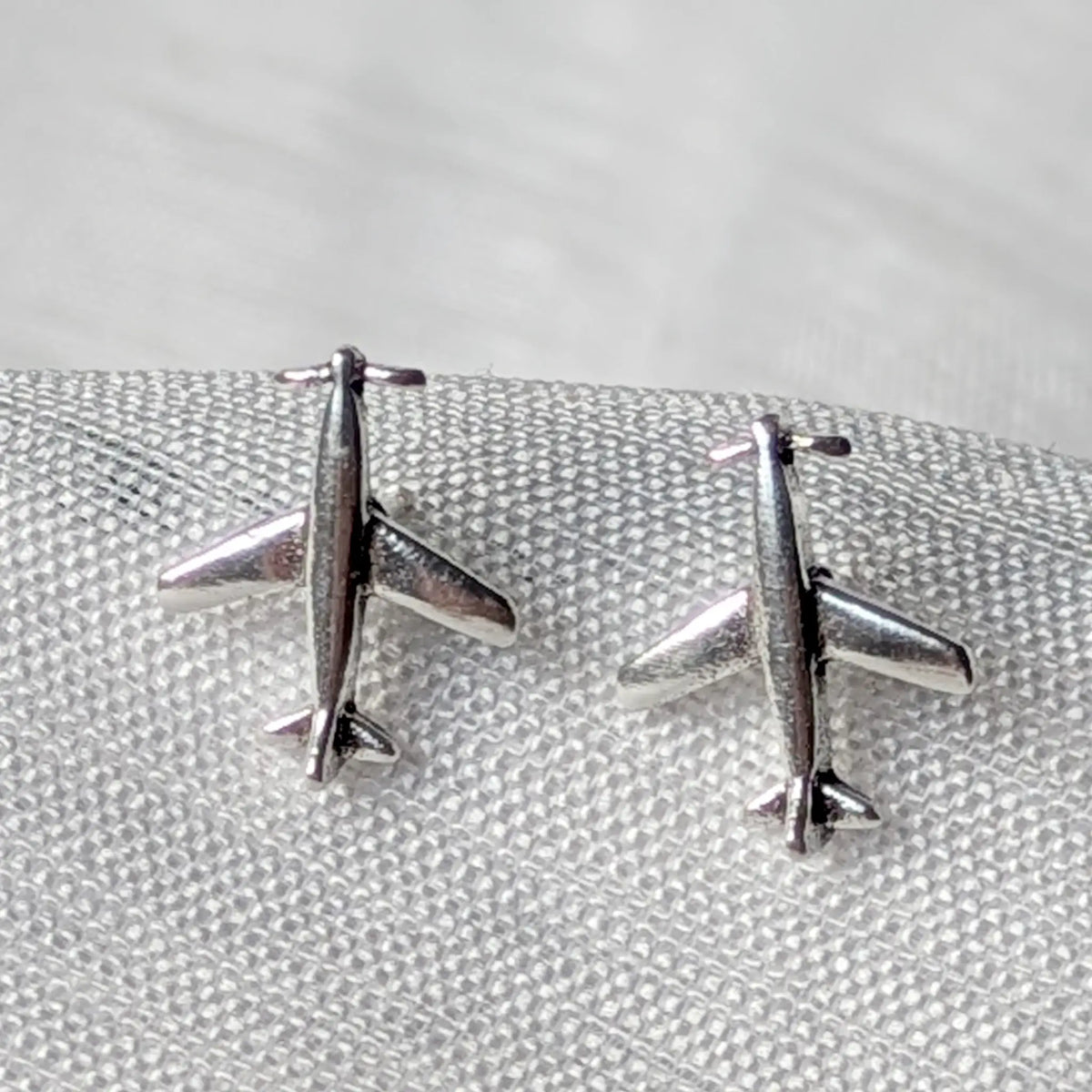 Nahaufnahme der Flugzeug-Ohrstecker aus 925 Sterling Silber mit detailliertem Flugzeugmotiv