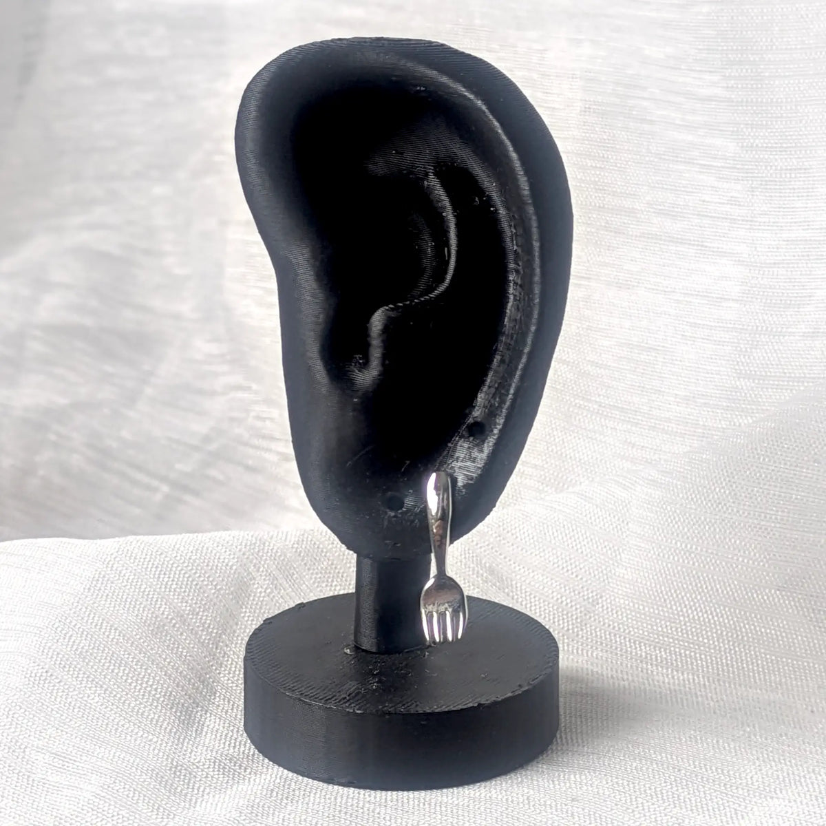 Ein silberner Gabel-Ohrstecker präsentiert an einem schwarzen 3D-Ohr-Display zur Veranschaulichung der Tragelänge.