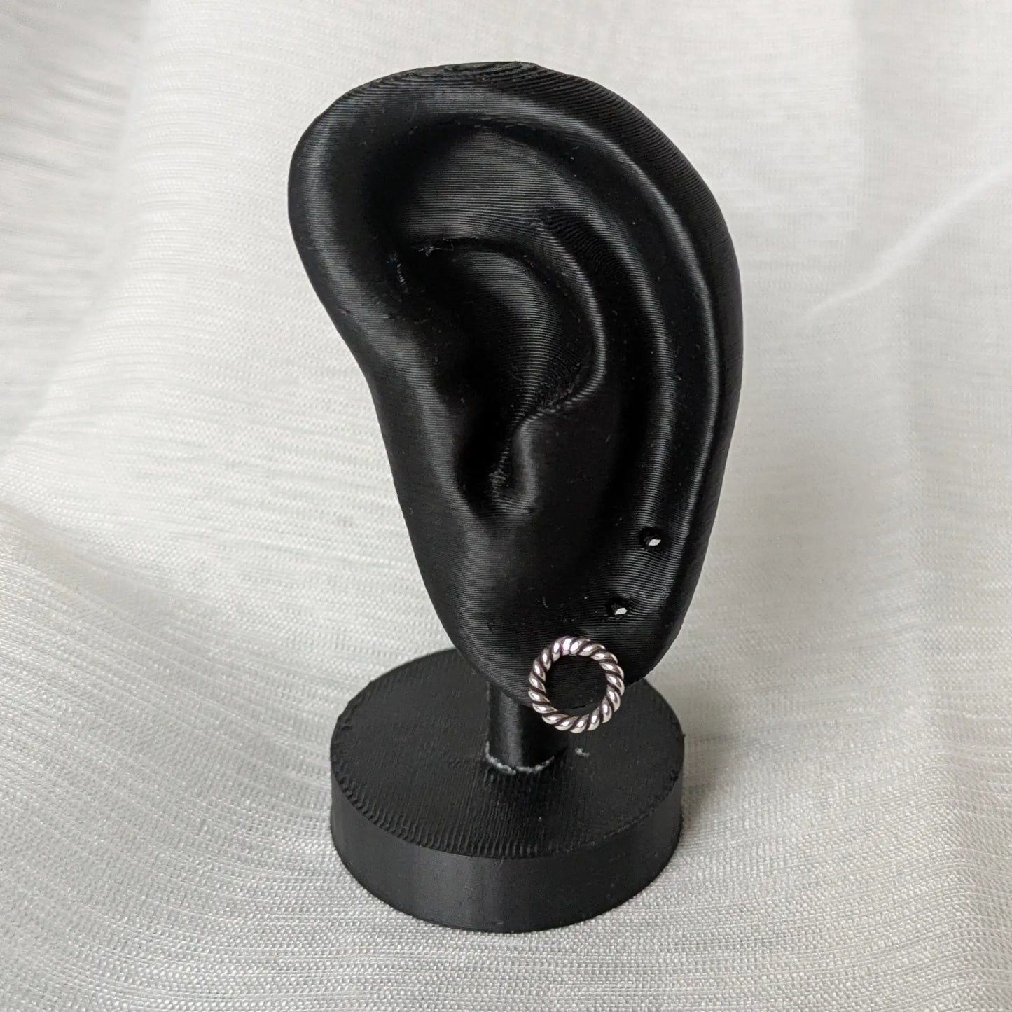 Gedrehter Silberstecker in kreisförmiger Form am Ohrdisplay