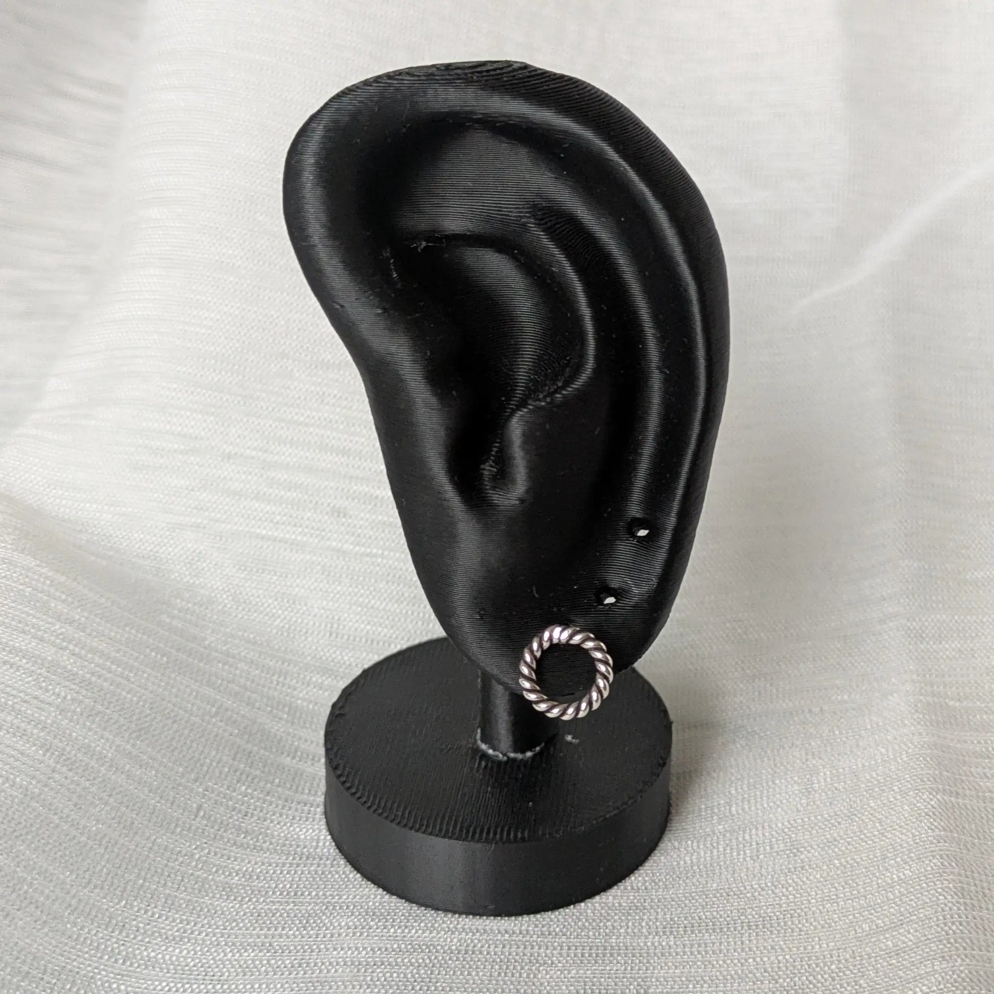 Gedrehter Silberstecker in kreisförmiger Form am Ohrdisplay