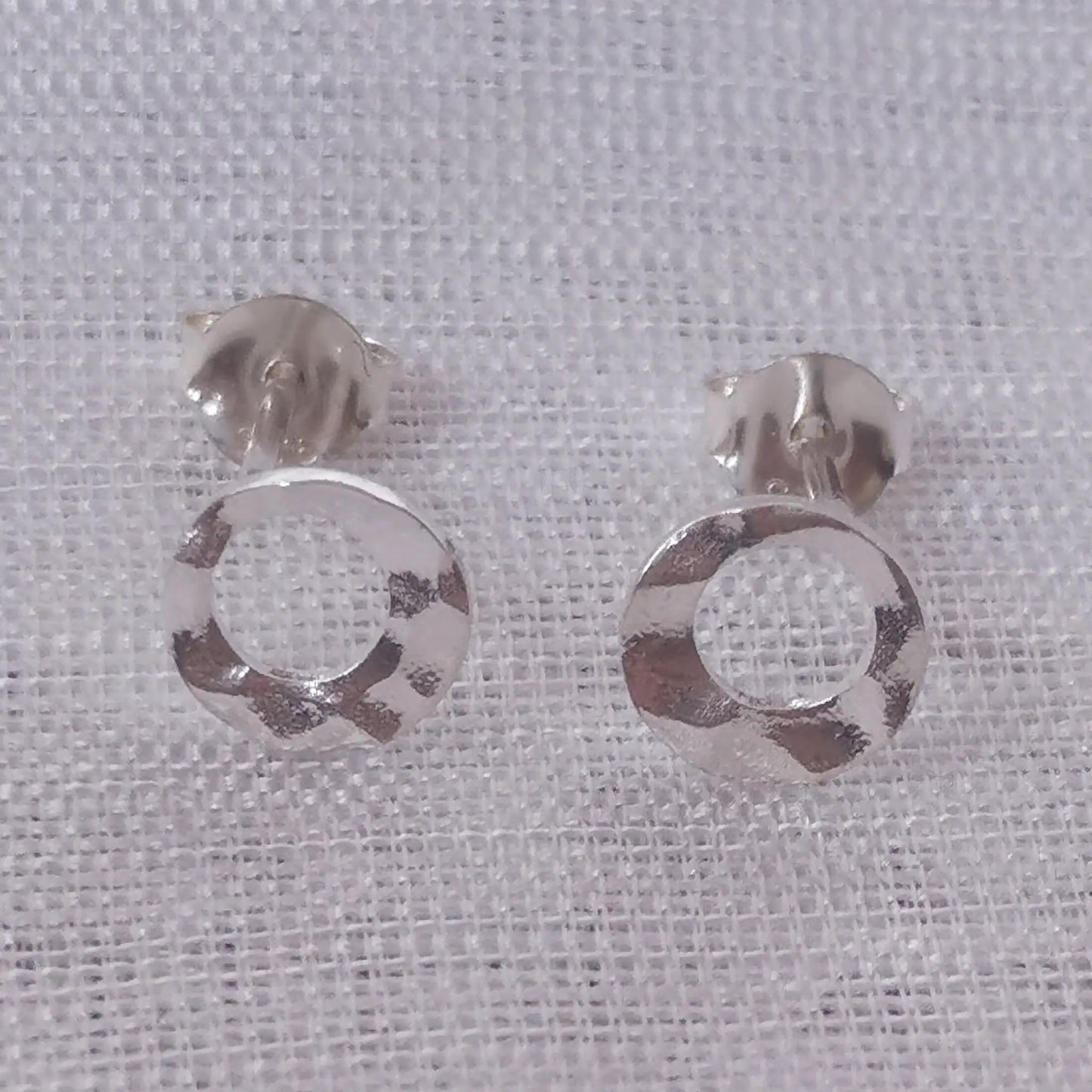 Frontale Produktansicht der runden 925 Sterling Silber Ohrringe zur Darstellung der gehämmerten Struktur und der offenen Kreisform.