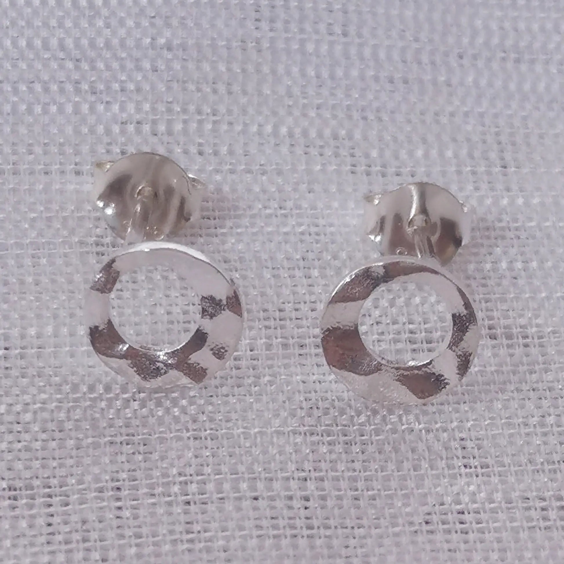 Frontale Produktansicht der runden 925 Sterling Silber Ohrringe zur Darstellung der gehämmerten Struktur und der offenen Kreisform.