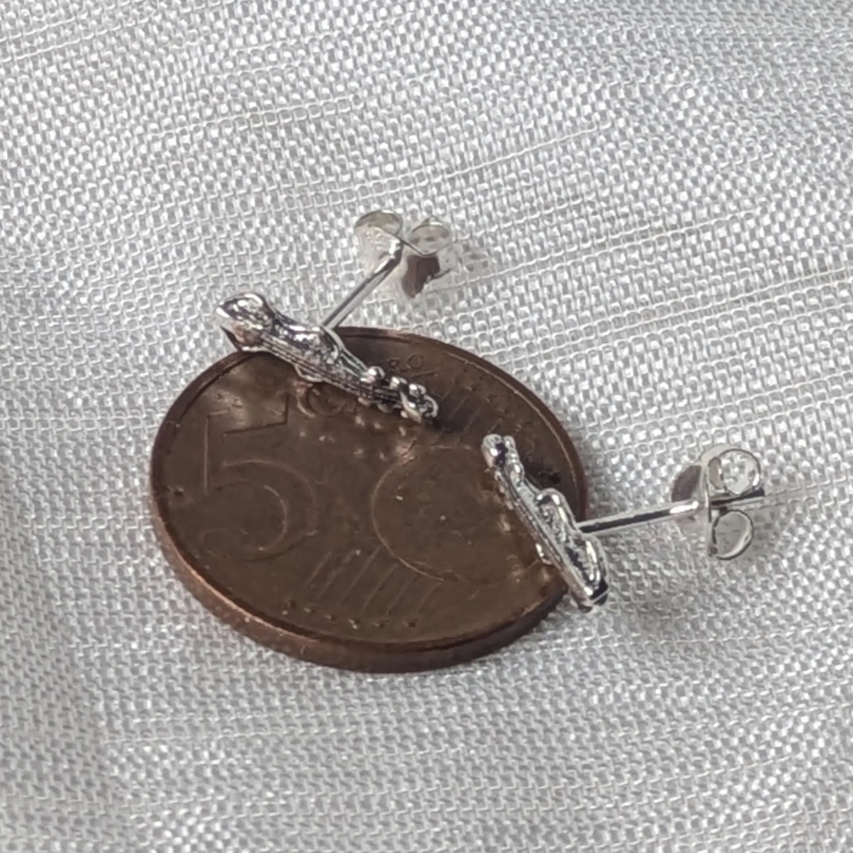 Größenvergleich der filigranen Violine-Silberohrstecker, flach liegend auf einer 5-Cent-Münze.
