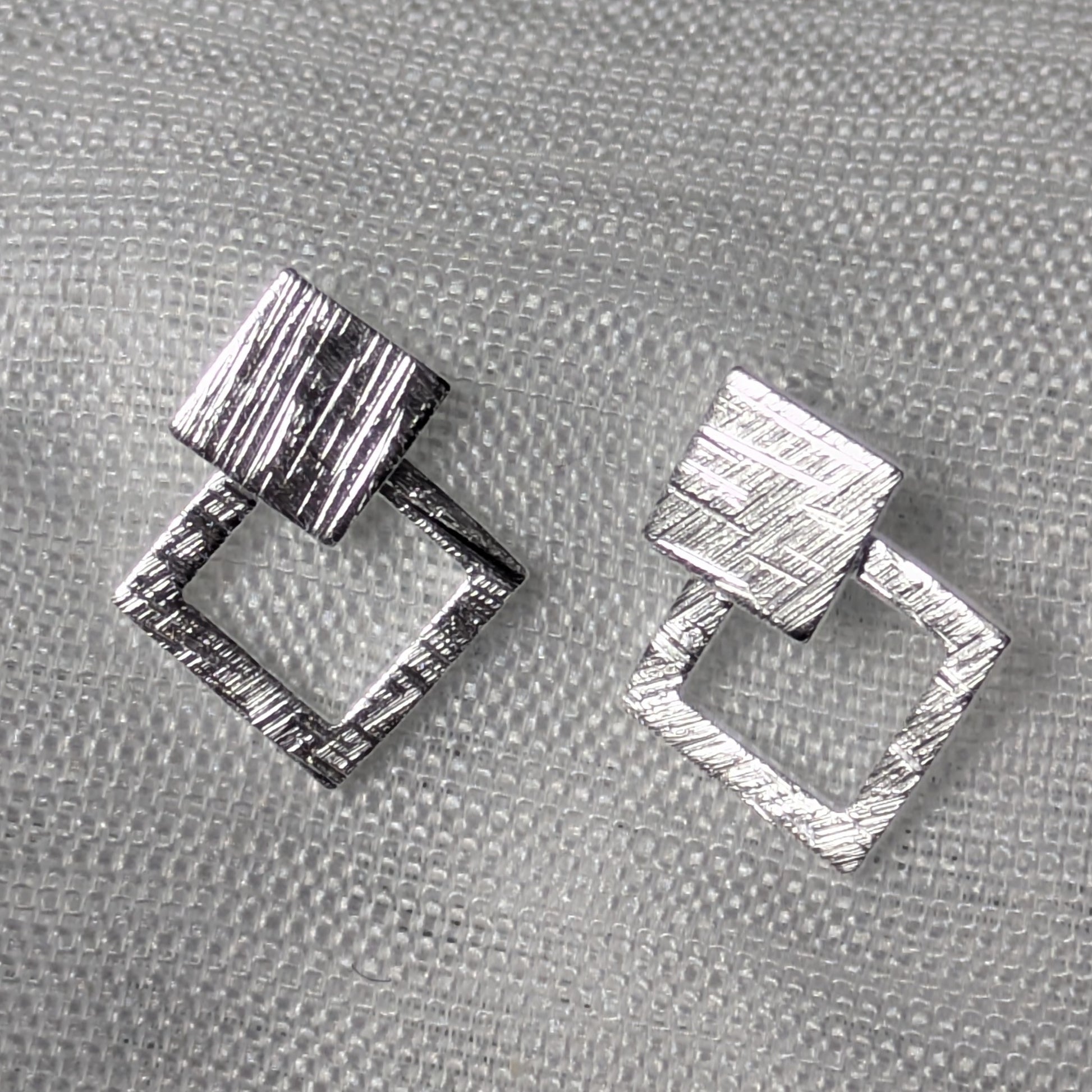 Frontale Ansicht der geometrischen Rauten-Ohrstecker aus Silber mit strukturierter Oberflächenprägung.
