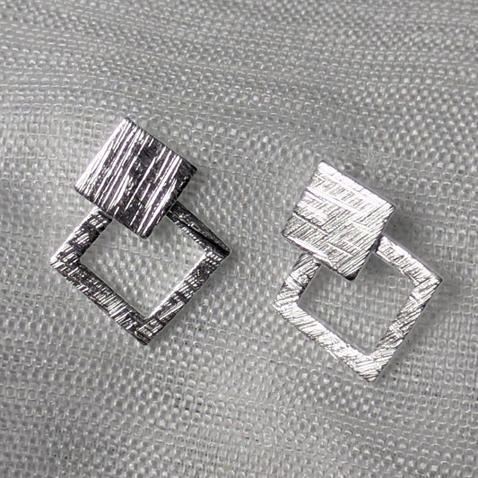 Frontale Ansicht der geometrischen Rauten-Ohrstecker aus Silber mit strukturierter Oberflächenprägung.