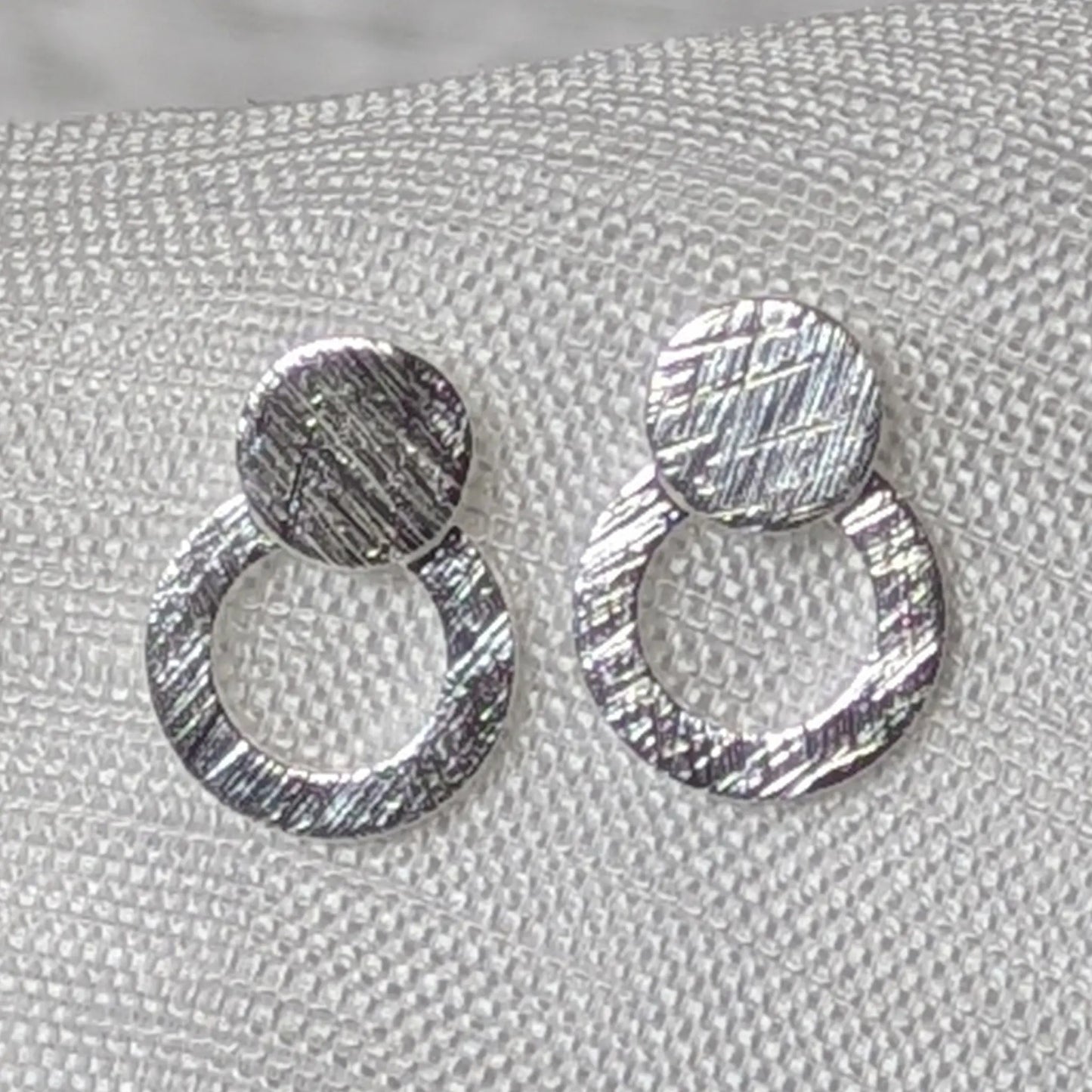 Detaillierte Nahaufnahme der strukturierten Oberfläche der 925er Silber Doppelkreis-Ohrstecker.