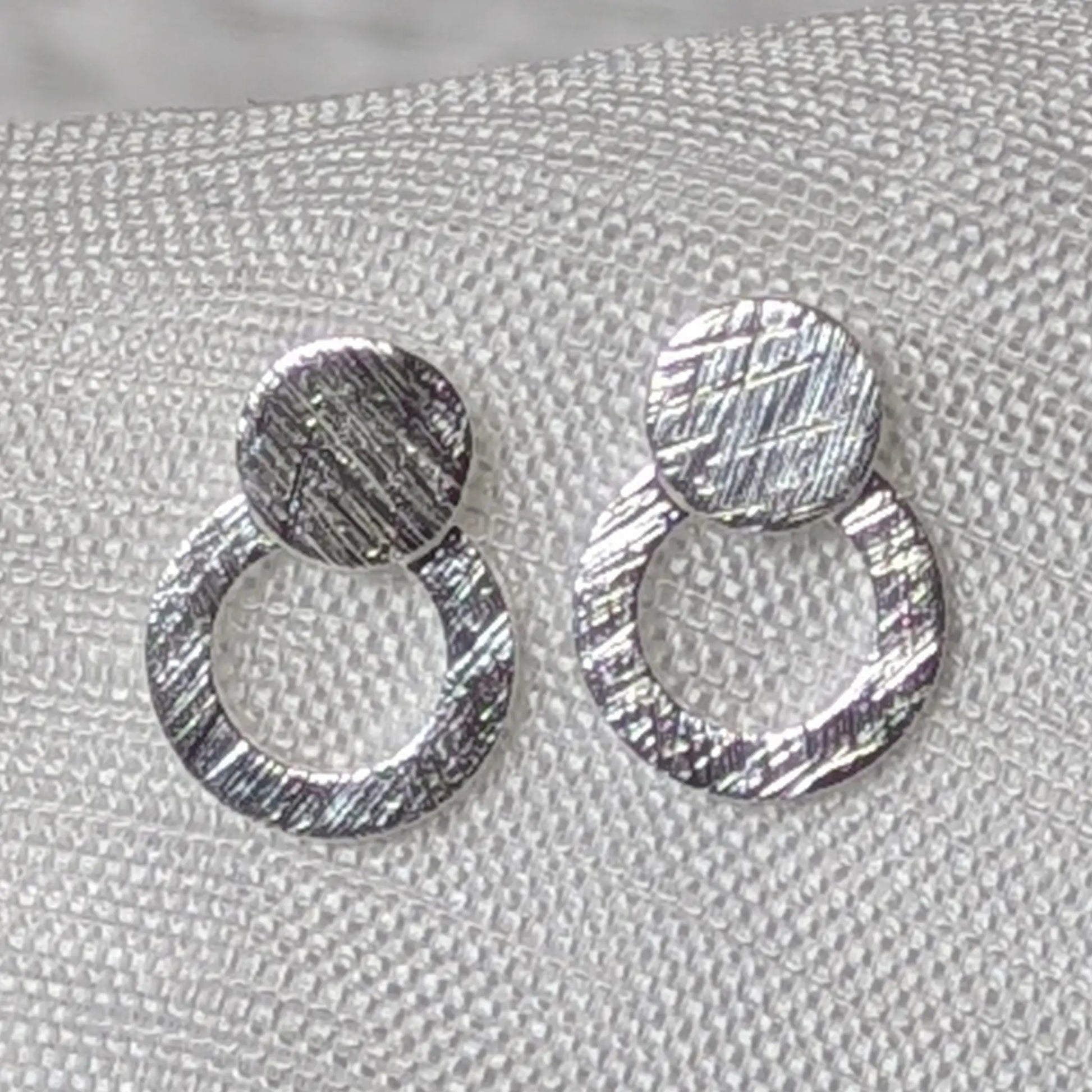 Detaillierte Nahaufnahme der strukturierten Oberfläche der 925er Silber Doppelkreis-Ohrstecker.