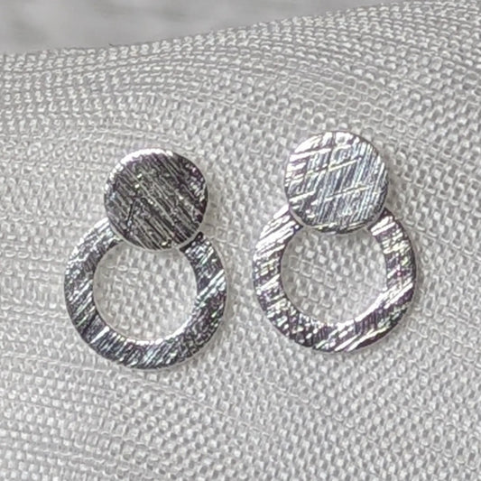 Detaillierte Nahaufnahme der strukturierten Oberfläche der 925er Silber Doppelkreis-Ohrstecker.