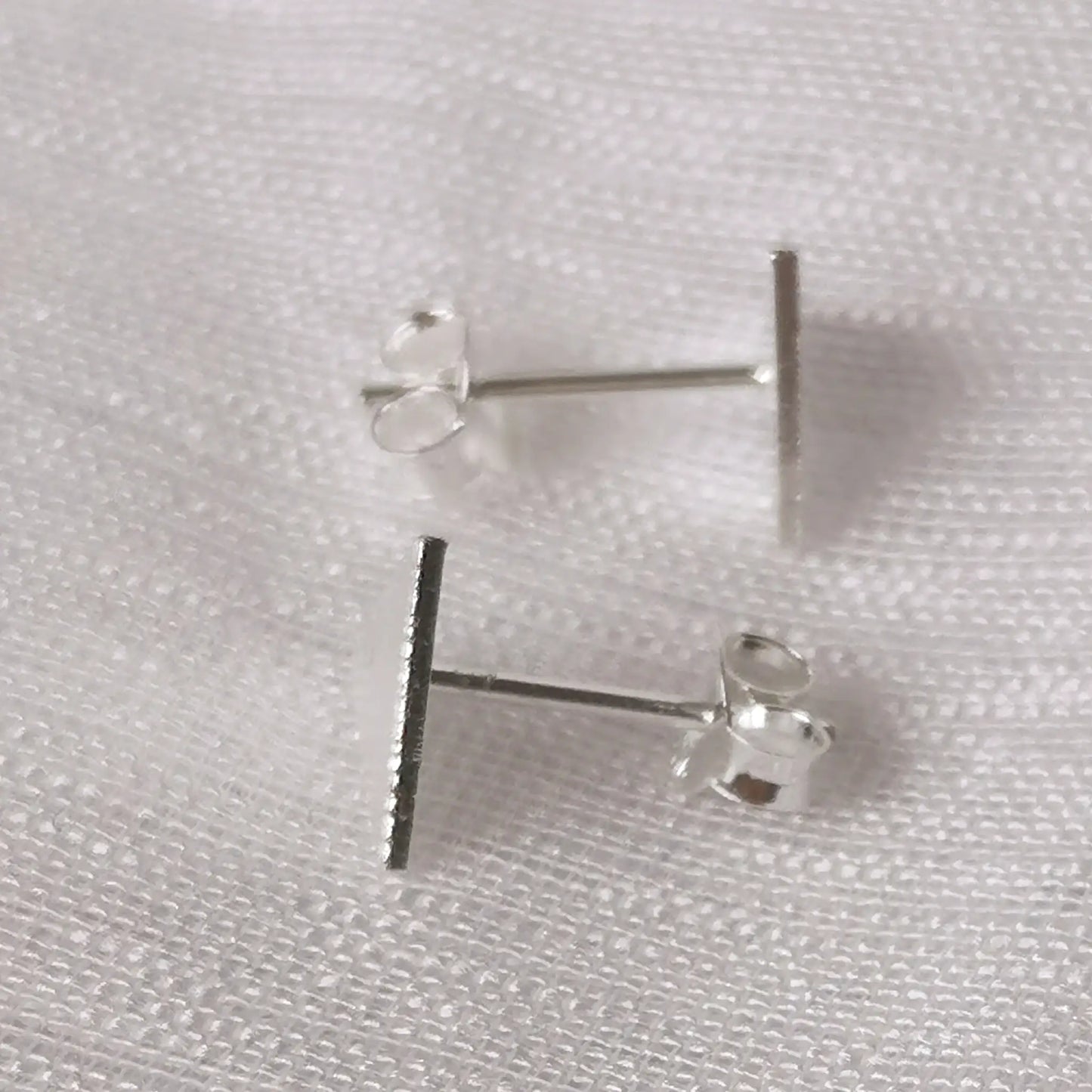 Seitliche Ansicht der silbernen Dreiecks-Ohrstecker zeigt die flache Verarbeitung und den stabilen Stecker-Stift aus 925 Silber.