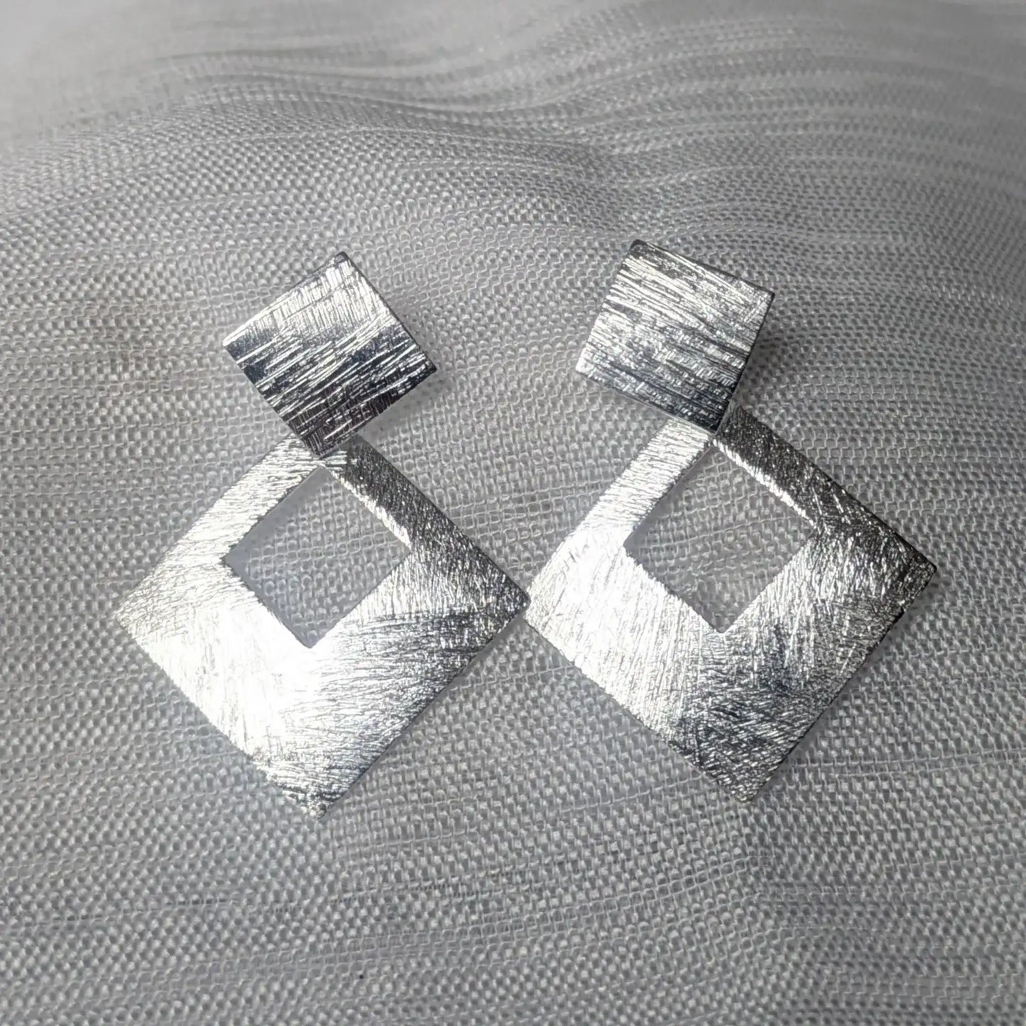Detailansicht der gebürsteten Oberfläche der quadratischen 925 Silber Ohrstecker.
