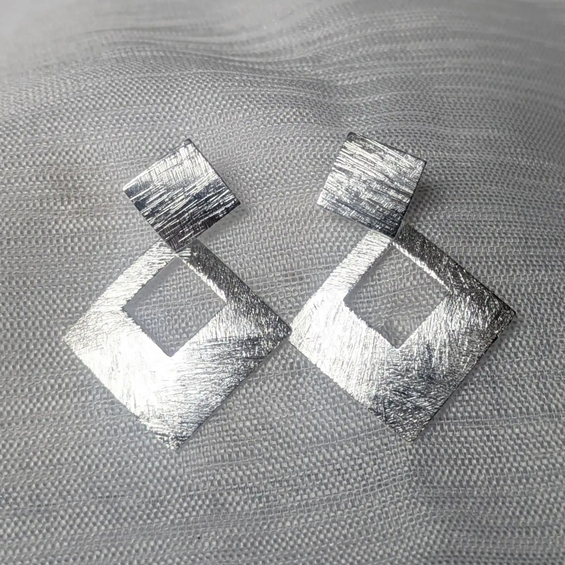 Detailansicht der gebürsteten Oberfläche der quadratischen 925 Silber Ohrstecker.