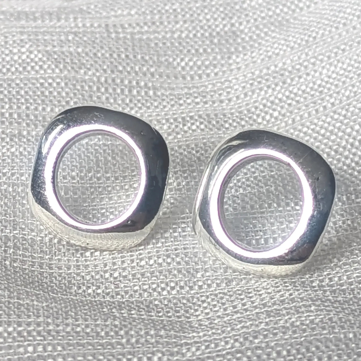 Detailaufnahme glänzende 925 Silber Ohrstecker, abgerundetes Quadrat mit mittigem Cut-out.