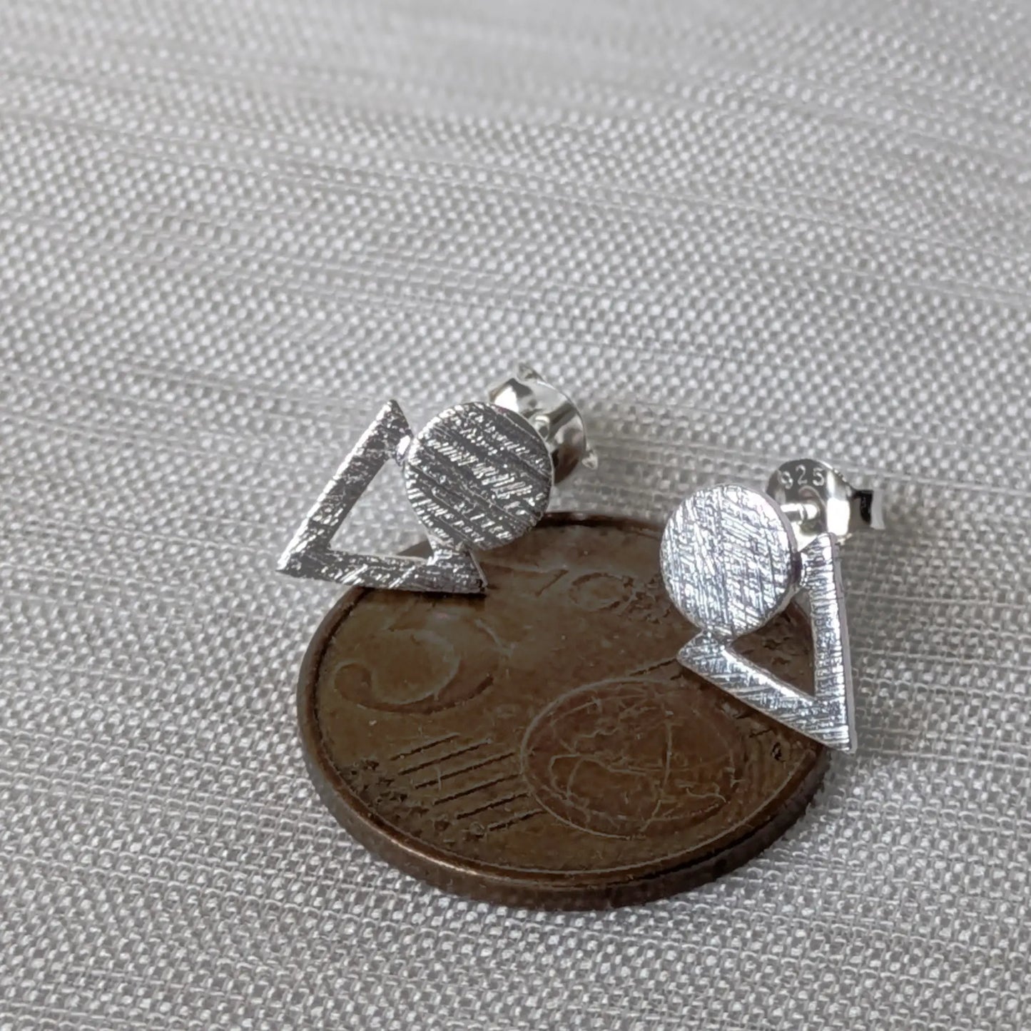 Größenvergleich: Ein texturierter geometrischer Silberohrring platziert auf einer 5-Cent-Münze.